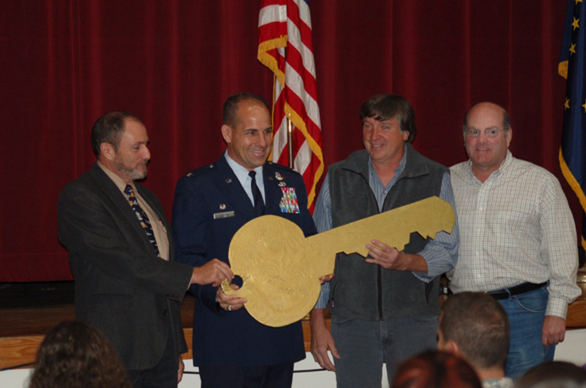 ELMENDORF AIR FORCE BASE, Alaska -- Col. Brent Johnson, 611th Air Support Group commander, second from left, presents the ceremonial key to the facilities at the former Galena Forward Operating Location to Harry White, Galena Interior Learning Academy principal, far left, Russ Sweetsir, Galena mayor, and Walt Wilcox, Galena city manager. GILA faculty and students, and other community members Sept. 23, gathered at the former Galena Forward Operating Location to commemorate the exchange of facilities from the Air Force to the school. The Air Force facilities will formally become the property of the city of Galena Oct. 1. (U.S. Air Force photo/Tommie Baker)