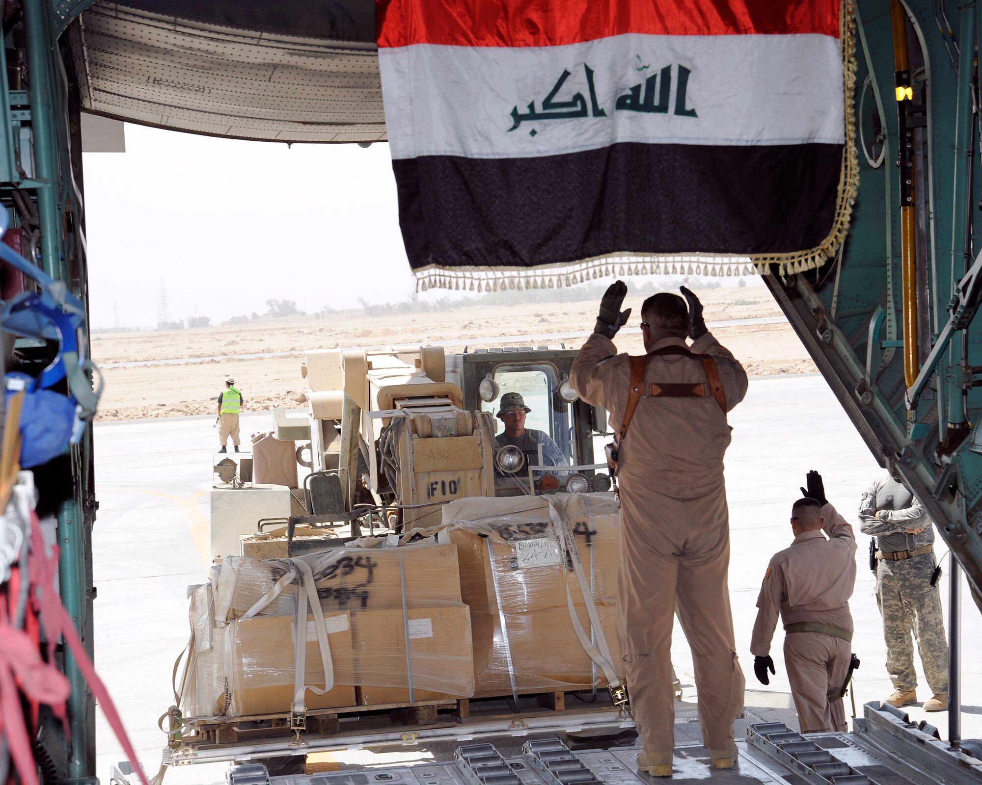 An Iraq air force loadmaster guides a forklift away from a C-130 Sept. 22 at an air base in Iraq. The Iraqis are off loading pallets of donated supplies for internally displaced families at Camp Al-Manathera. The supplies consist of childrens clothes, winter coats, shoes, burn medicine and wheelchairs. (U.S. Air Force photo/Staff Sgt. Paul Villanueva II)