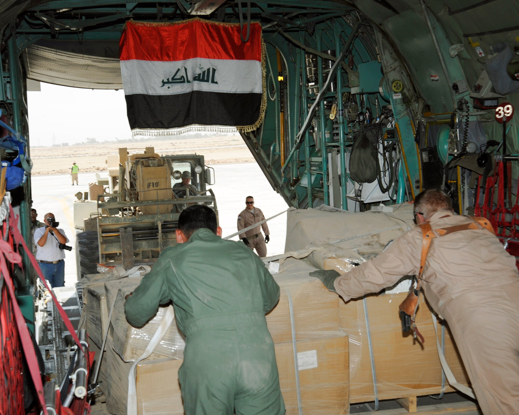 An Iraqi aircrew pushes a pallet off an Iraqi C-130 Sept. 22 at an air base in Iraq. This was the first Iraqi air force C-130-supported humanitarian airlift to Najaf, Iraq. The supplies are to be donated to internally displaced Iraqis at Camp Al-Manathera. (U.S. Air Force photo/Staff Sgt. Paul Villanueva II) 
