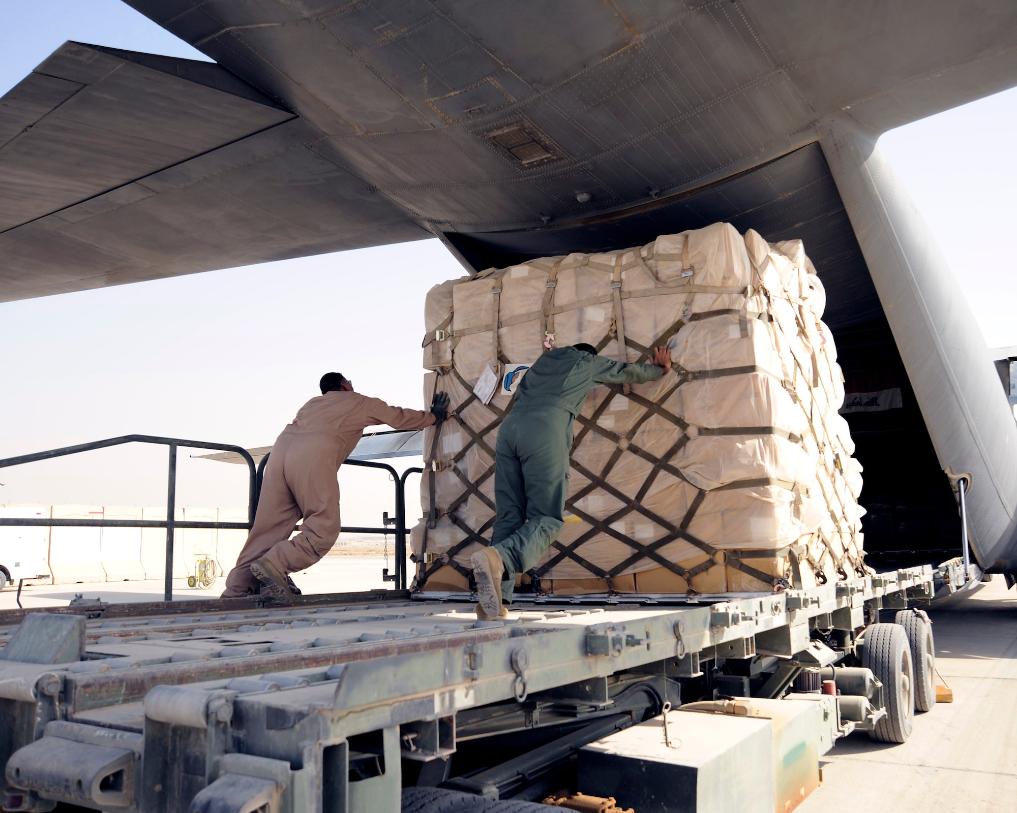 Iraq air force loadmasters push a pallet of donated supplies onto an Iraqi C-130 Sept. 22 at an air base in Iraq. This was the first Iraqi air force C-130-supported humanitarian airlift to Najaf, Iraq. The supplies are to be donated to internally displaced Iraqis at Camp Al-Manathera. (U.S. Air Force photo/Staff Sgt. Paul Villanueva II)
