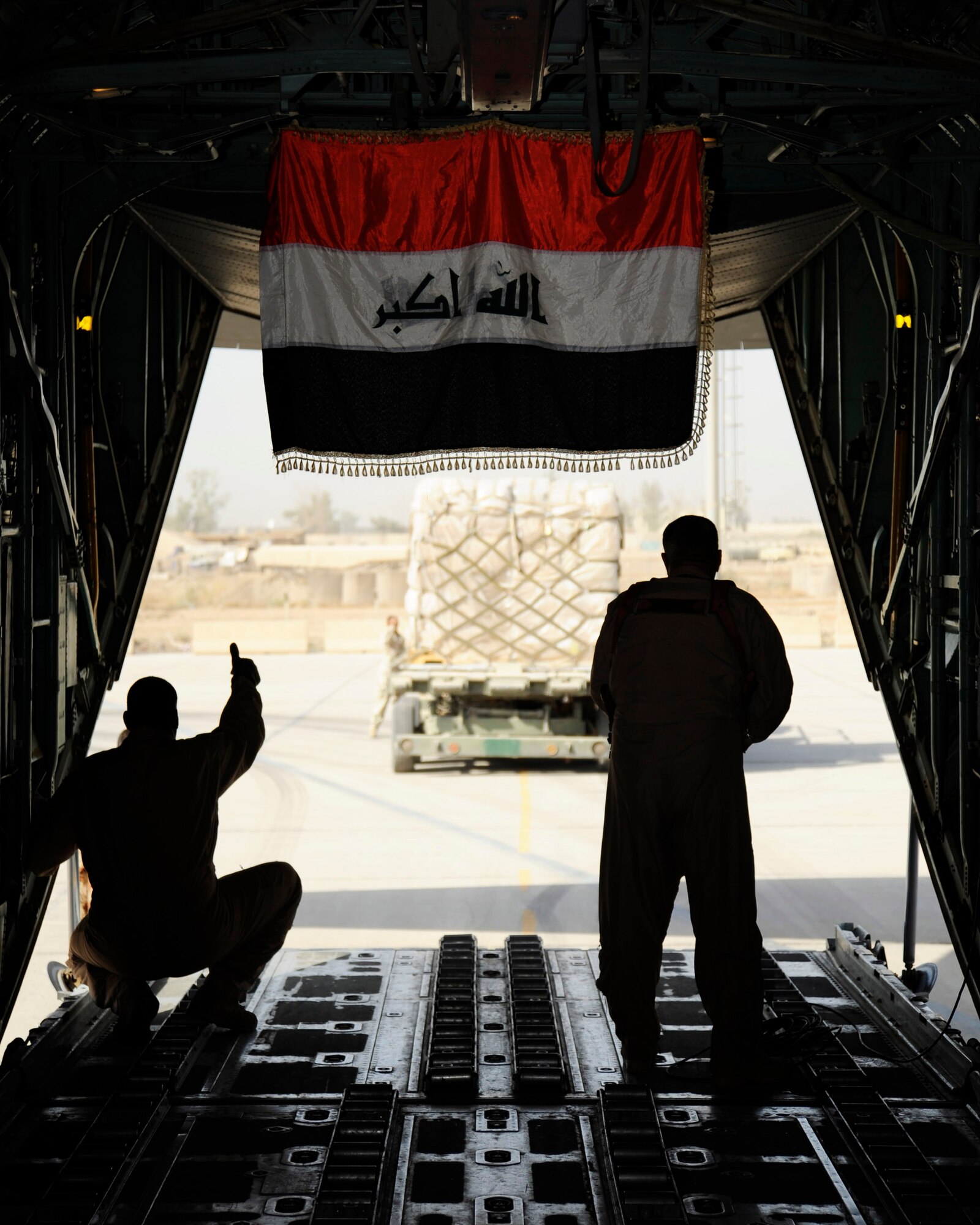 Iraq air force loadmasters guide a K-loader to an Iraqi C-130 Sept. 22 at an air base in Iraq. The cargo consists of wheelchairs, burn medicine, children's clothes and shoes for the first Iraqi air force C-130-supported humanitarian airlift to Najaf, Iraq. The supplies are to be donated to internally displaced Iraqis at Camp Al-Manathera. (U.S. Air Force photo/Staff Sgt. Paul Villanueva II)
