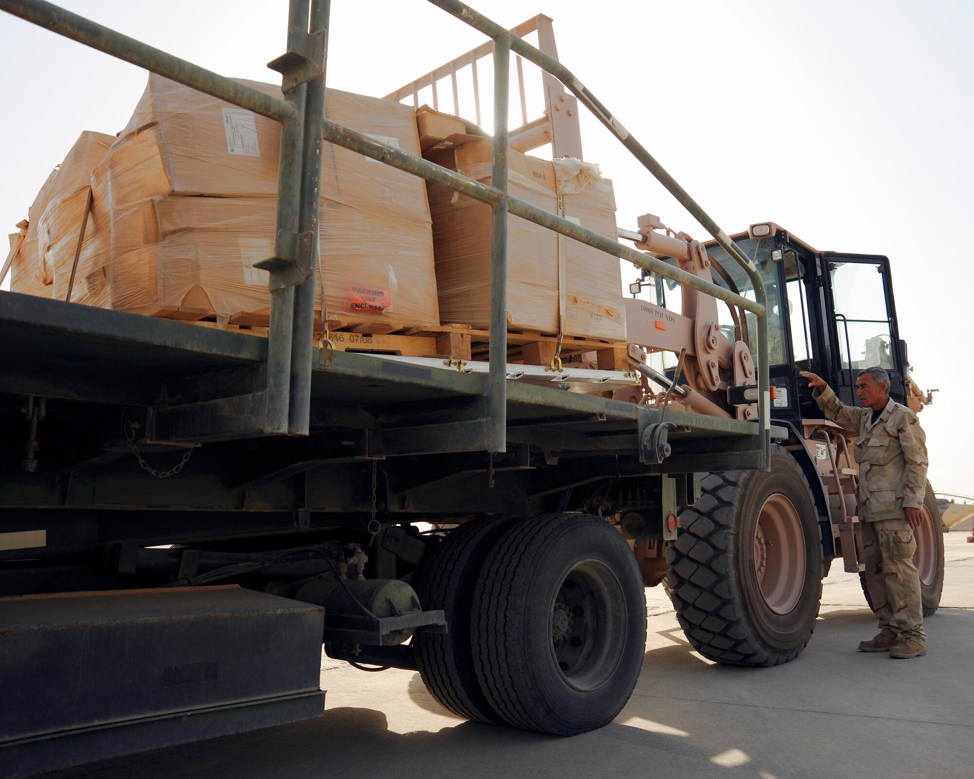 An Iraq air force loadmaster guides a pallet onto a K-loader Sept. 22 at an air base in Iraq. The supplies are to be donated to internally displaced families in Najaf, Iraq. This is the first Iraqi air force supported humanitarian airlift to Najaf. (U.S. Air Force photo/Staff Sgt. Paul Villanueva II)

