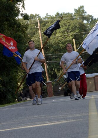 2nd Lt. Timothy Denhoed, left, leads Airmen in a formation run on their first lap at the POW/MIA 24-hour vigil run at the base Commissary Sept. 24. Airmen from Charleston AFB were joined by service members and cadets representing the other branches of the military throughout the 24-hour period to honor United States military members taken as prisoners of war and those who are still missing in action. Lieutenant Denhoed is assigned to the 437th Force Support Squadron. (U.S. Air Force photo/Airman 1st Class Timothy Taylor)