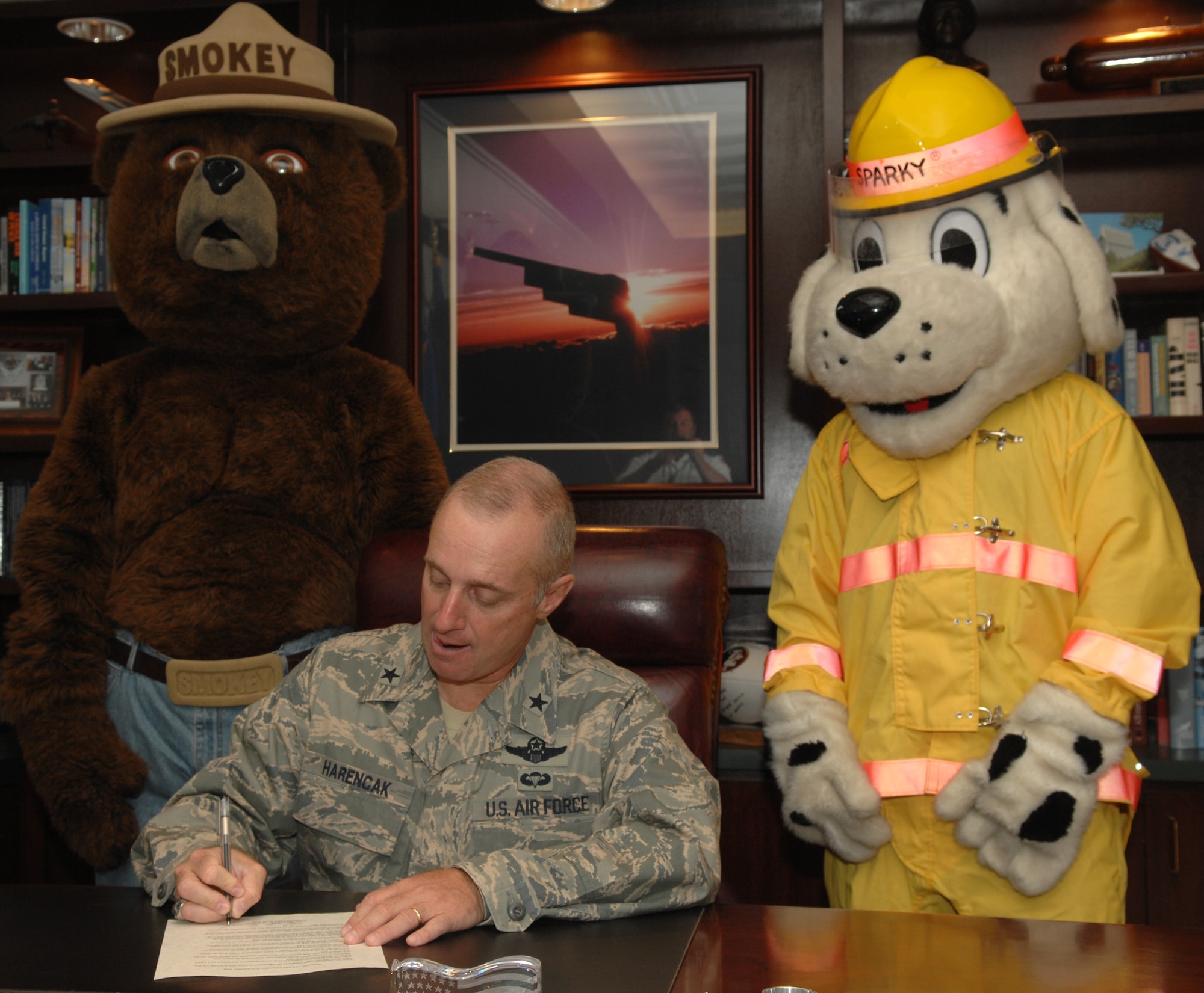 WHITEMAN AIR FORCE BASE, Mo. - Brig. Gen. Garrett Harencak, 509th Bomb Wing commander, signs this year's fire proclamation as Smokey the bear and Sparky standby Sept. 24. Fire Prevention Week has been declared as Oct. 5-11, and the Whiteman Fire and Emergency Services Flight has planned several events to further educate the base populace. (U.S. Air Force photo/Senior Airman Stephen Linch) 
