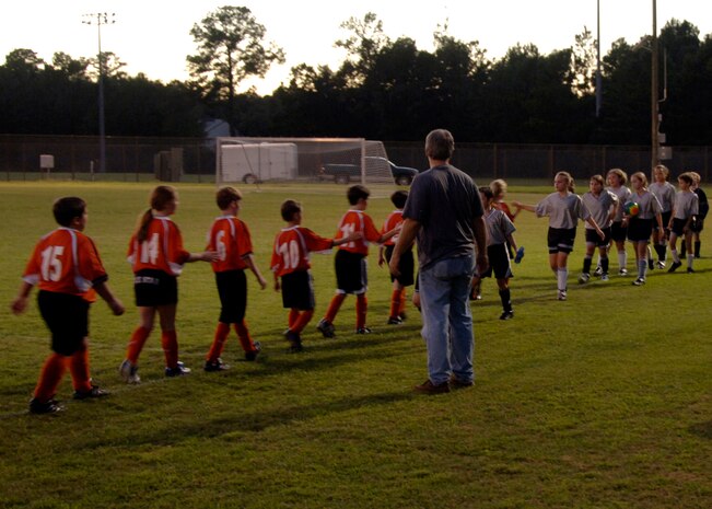 Both teams high-five each other after the game to show good sportsmanship and to congratulate each other for a hard fought match at the base soccer field Sept. 22. The Hanahan Starz defeated the Silver Bullets 2-1. (U.S. Air Force photo/Airman 1st Class Timothy Taylor)