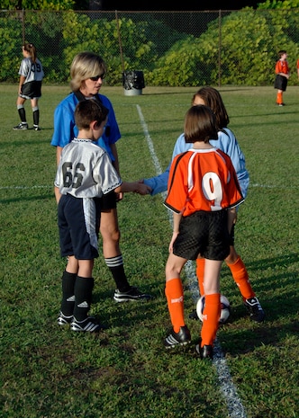 Silver Bullets and Hanahan Starz team captains shake hands before the coin toss at the base soccer field Sept. 22. The coin toss decides which team gains possession of the ball to begin the game. The Silver Bullets are Charleston AFB's youth soccer team. (U.S. Air Force photo/Airman 1st Class Timothy Taylor)