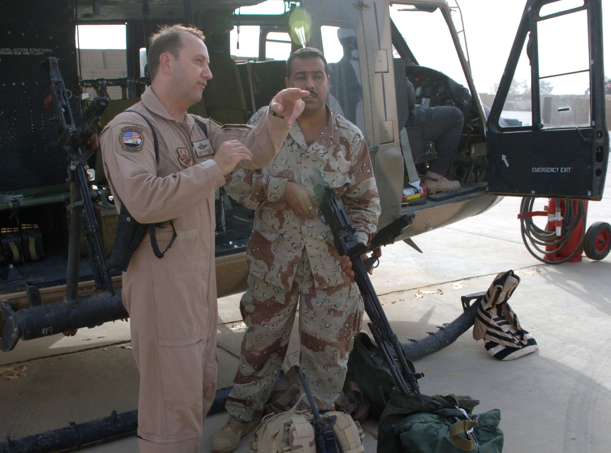 Master Sgt. Dean Marquis discusses a gunnery training mission with Iraqi air force Pvt. Fadhil Faleh at Taji Air Base, Iraq, Sept. 12. Faleh is an apprentice Mi-17 Hip gunner with 2nd Squadron. Marquis, the 770th Air Expeditionary Advisory Squadron's operations superintendent, is deployed from Hurlburt Field, Fla. (U.S. Air Force photo/Tech. Sgt. Richard Lisum)