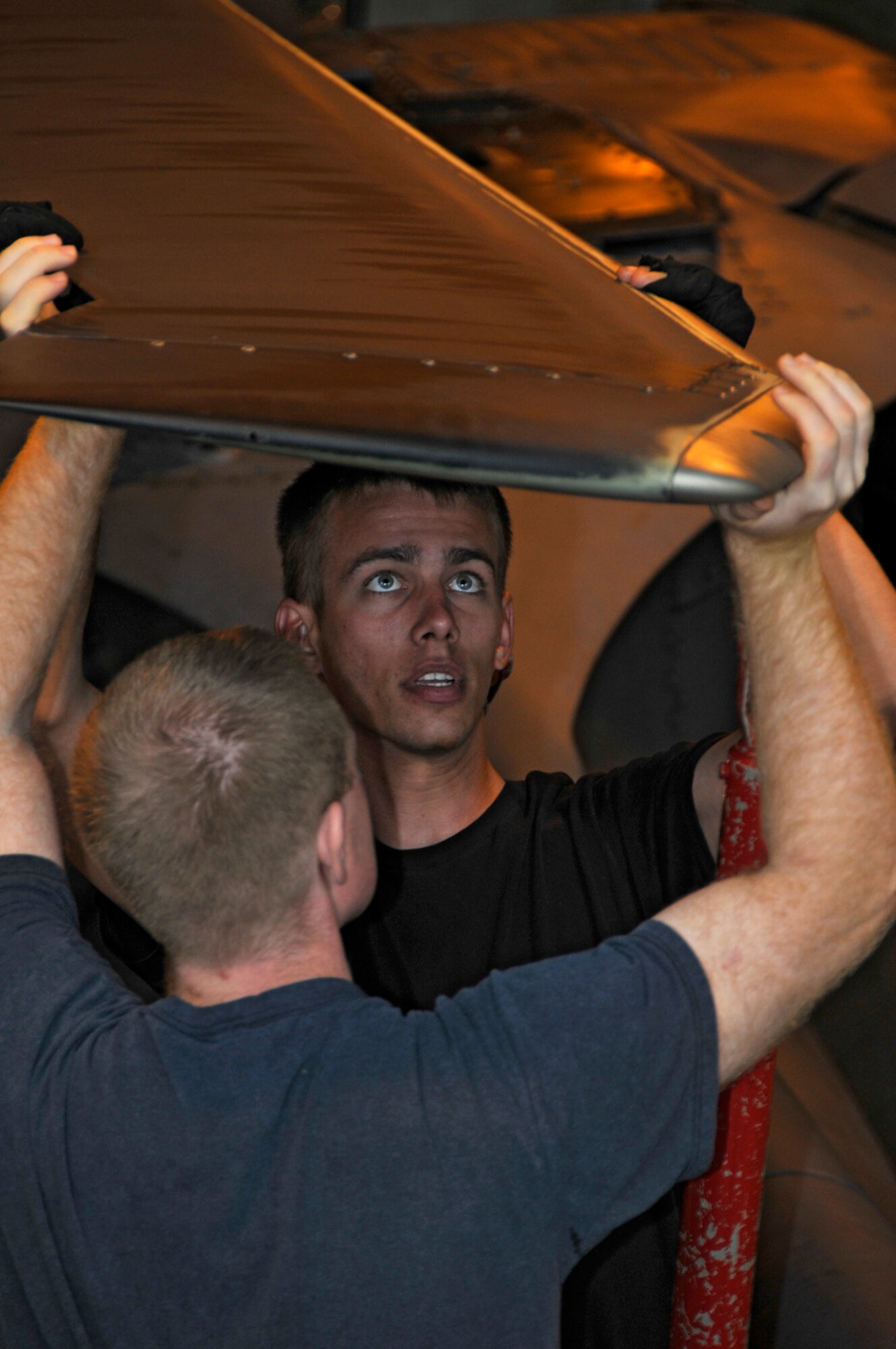 Staff Sgt. John Powers, 48th Aircraft Maintenance Squadron HH-60G helicopter crew chief, helps Airman 1st Class Brandon Parisi, 48th Aircraft Maintenance Squadron HH-60G helicopter crew chief, secure the main rotor blade from an HH-60G Pave Hawk to the tail boom adapter Sept. 11 at RAF Lakenheath, England. (U.S. Air Force photo by Airman 1st Class Perry Aston)