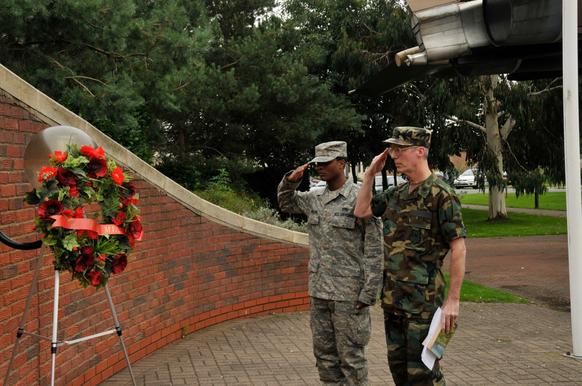 Airman 1st Class Steven Copeland, 48th Component Maintenance Squadron, and Chaplain (Lt. Col.) Joseph Dowling, 14th Flying Training Wing, Columbus Air Force Base, Miss. salute a wreath at The Least We Forget Memorial and Air Park Sept. 16 at RAF Lakenheath, England.  (U.S. Air Force photo by Airman 1st Class Perry Aston)