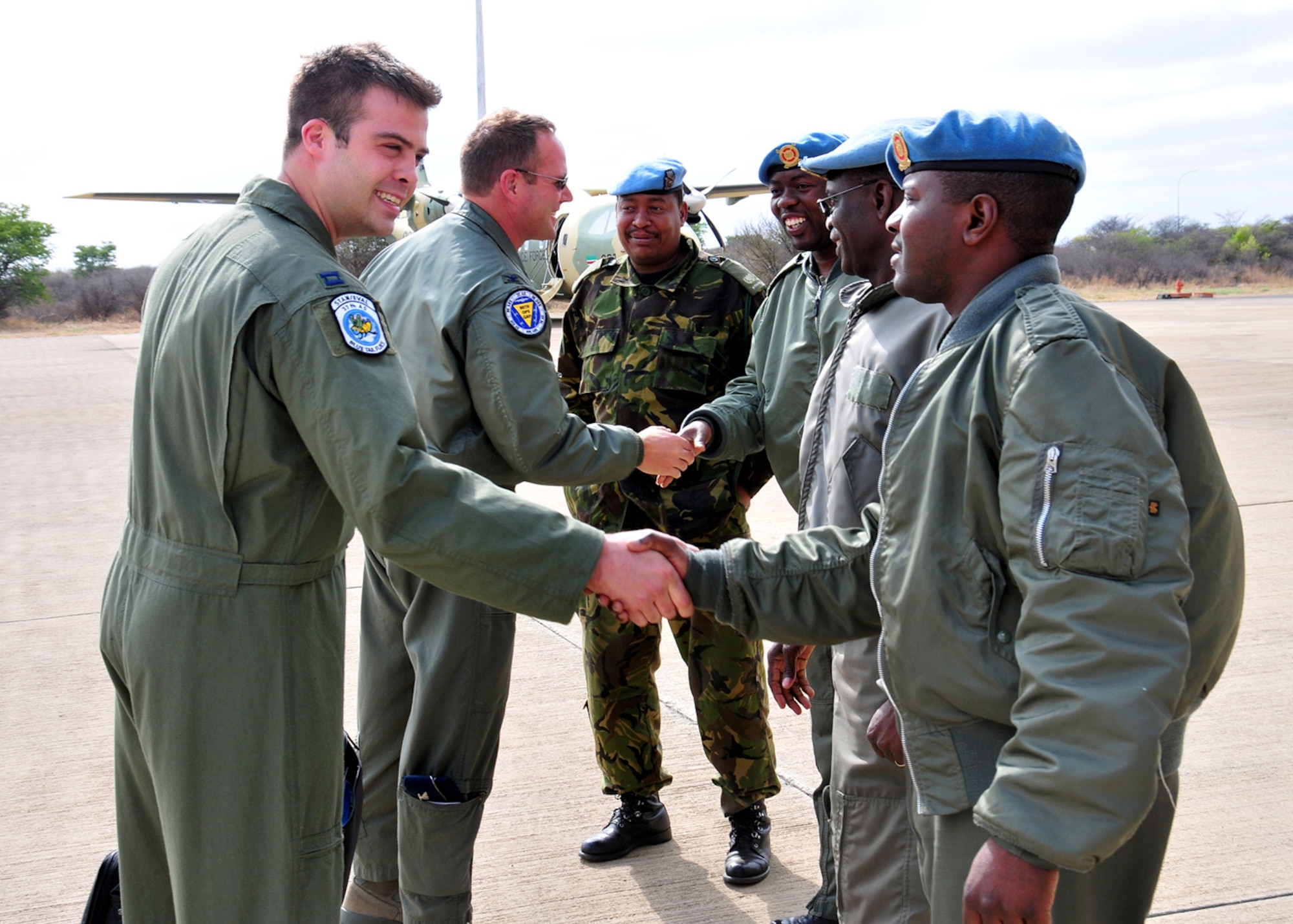United States Air Force Col. Ty Thomas, 86th Operations Group commander, and Capt. Marc Andrews, 37th Airlift Squadron C-130 navigator, are greeted by members of the Botswana Defense Force upon their arrival. (U.S. Air Force photo by Staff Sgt. Marcus Maier)(Released)