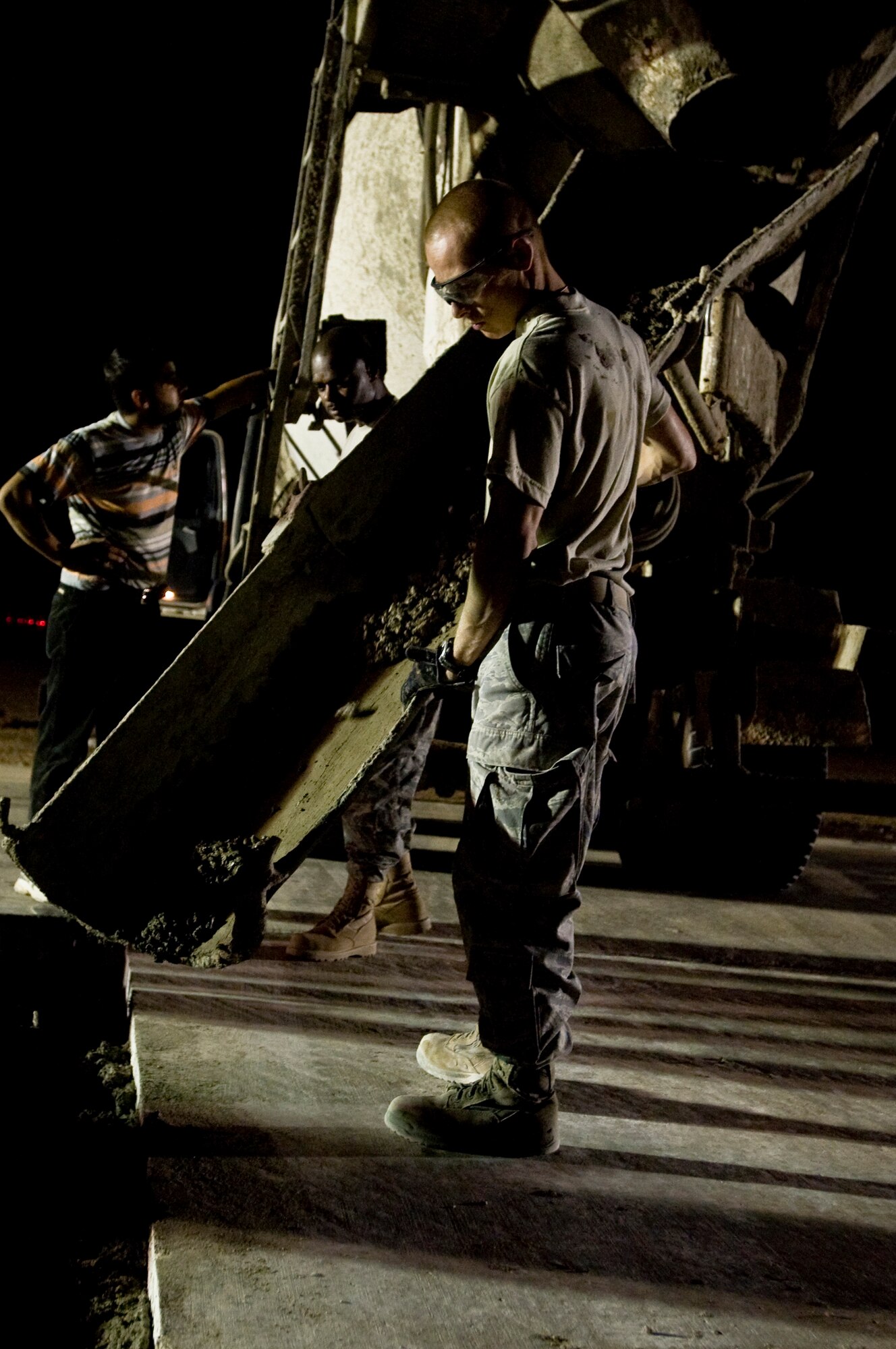 ALI BASE, Iraq -- Senior Airman Ian Newkirk, 407th Expeditionary Civil Engineer Squadron, moves the cement to evenly fill holes on the taxiway Sept. 22, 2008. Extreme heat conditions, along with normal wear and tear, can cause cracks or pot holes on the runways, which makes it unsafe for aircraft. Airmen of the 407th ECES ensure the flight line is serviceable at all times by fixing any reported damage. Newkirk is deployed from Malmstrom Air Force Base, Mont. (U.S. Air Force photo/Airman 1st Class Christopher Griffin)