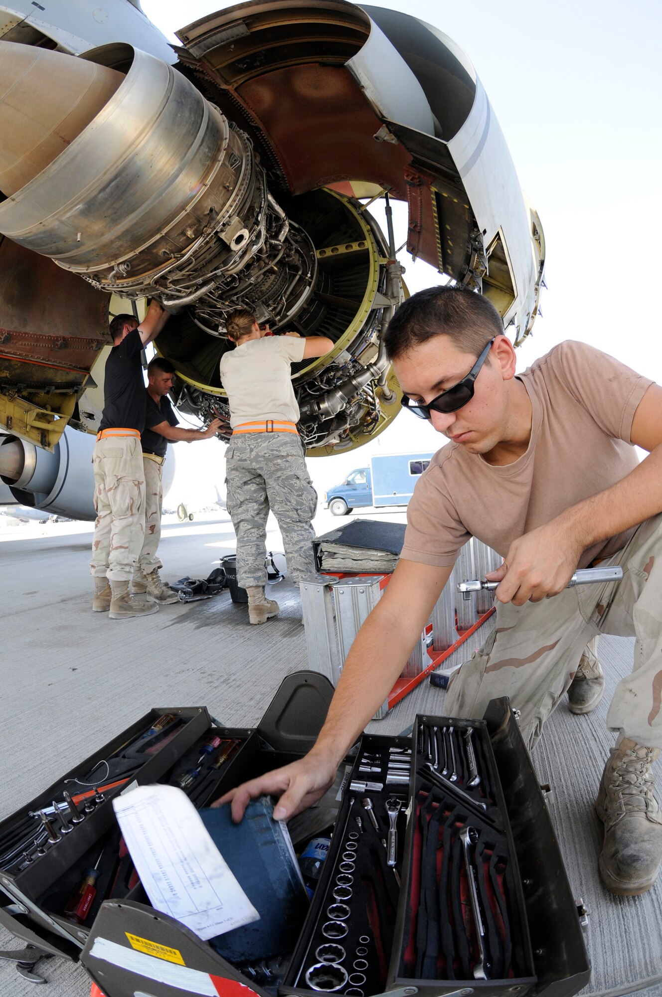 Senior Airman Joshua Eisel reaches inside a toolbox to finish setting up a torque wrench to assist KC-135 engine maintenance being performed by Tech. Sgt. Brian McColm, Staff Sgt. Brian Kelty, and Airman 1st Class Erin Story Sept. 23, 2008, at an undisclosed air base in Southwest Asia. All are aerospace propulsion specialists assigned to the 379th Expeditionary Aircraft Maintenance Squadron. The hard work performed by members of the 379 AMXS keep aircraft flying in support of Operations Iraqi Freedom, Enduring Freedom and Joint Task Force-Horn of Africa. Airman Eisel, a native of Toledo, Ohio, is deployed from MacDill Air Force Base, Fla. Sergeant McColm, a native of Cherokee, Kan., is deployed from McConnell AFB, Kan.  Sergeant Kelty hails from Youngstown, Ohio, and is deployed from Grand Forks AFB, N.D. Airman Story, originally from Jump River, Wis., is deployed from MacDill Air Force Base, Fla. (U.S. Air Force photo by Staff Sgt. Darnell T. Cannady/Released)