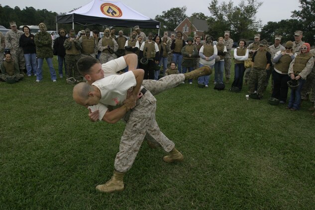 Gunnery Sgt. Daniel P. Schismenos tosses Capt. Joshua Bourne as part of a Marine Corps Martial Arts Program demonstration during the U.S. Marine Corps Forces, Special Operations Command, Marine Special Operations Support Group Jane Wayne Day in front of the Goettge Field House here, Sept. 24.The two Marines with Support Company, MSOSG, MARSOC, organized most of the events and demonstrations during the Jane Wane Day.