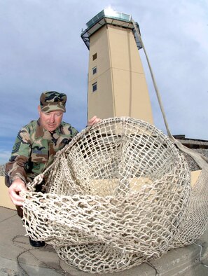 FAIRCHILD AIR FORCE BASE, Wash. – Senior Master Sgt. Dennis Brooks, 92nd Operations Support Squadron chief controller, performs a visual inspection on the life chute Sept. 24. This training is done annually to practice egress procedures from Fairchild’s Air Traffic Control Tower. (U.S. Air Force photo / Staff Sgt. JT May III)
