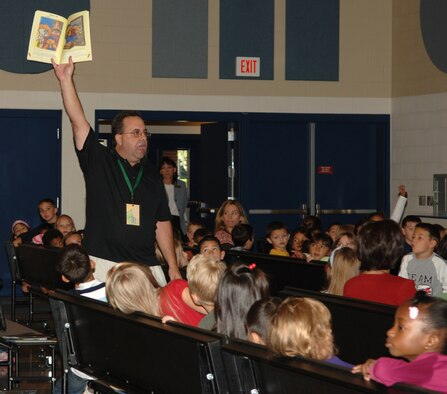 FAIRCHILD AIR FORCE BASE, Wash. – Sam X Renick, author, shows off the illustrations from his book as he reads to more than 300 students at Michael Anderson Elementary School Sept. 23. Mr. Renick is the founder and CEO of “It’s A Habit!” Company whose mission is to provide educational and entertaining tools across the globe that encourage good habits, especially the good habit of saving money. (U.S. Air Force photo / Senior Airman Jocelyn A. Ford)