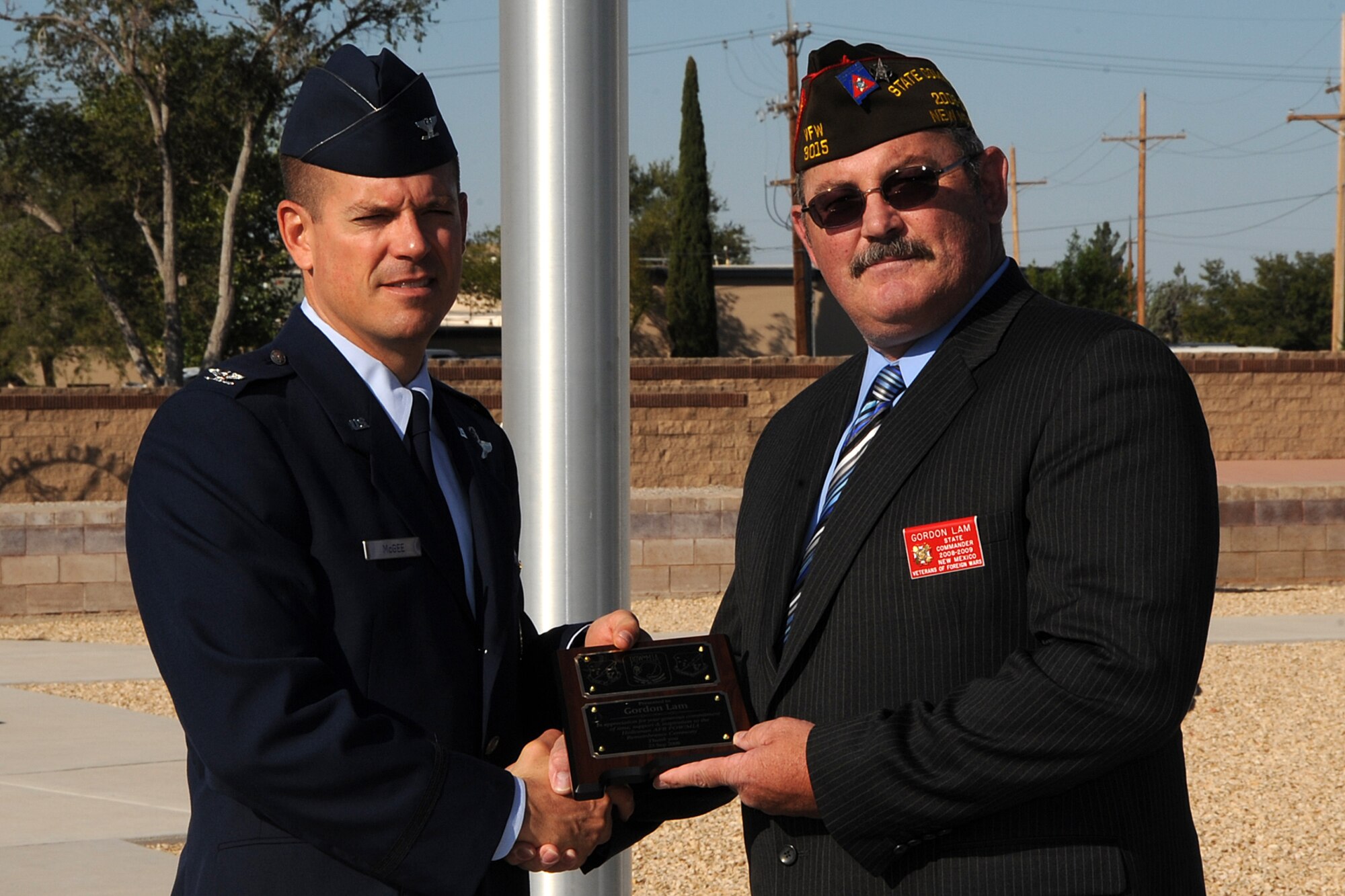 Col. Michael McGee, 49th Fighter Wing vice commander, presents a token of appreciation to Mr. Gordon K. Lam September 23. Mr. Lam is the New Mexico president of the Veterans of Foreign Wars and spoke to Team Holloman members at the Prisoners of War/ Missing in Action Day ceremony. (U.S. Air Force photo/ Staff Sgt. Chris Flahive)