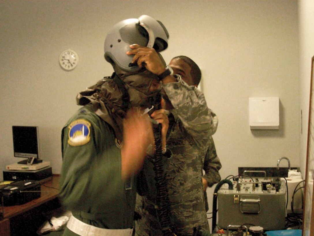 Staff Sgt. Robert Tull II, 459th Operations Support Flight security officer, assists Lt. Col. Dennis Thornton with donning his aircrew chemical ensemble during the 459th's Nuclear Operational Readiness Inspection held Sept. 19-21. (USAF courtesy photo)