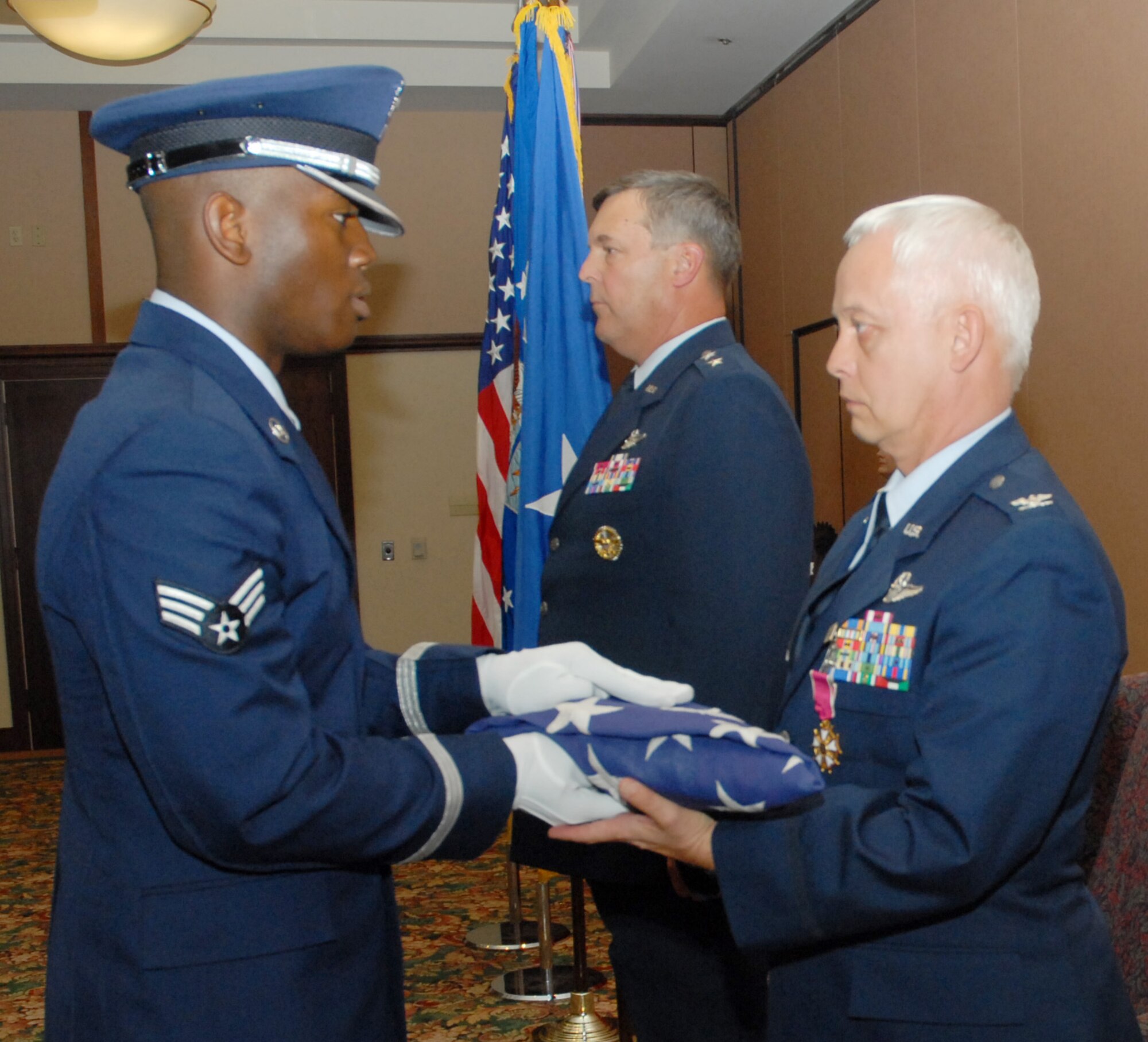 BEALE AIR FORCE BASE, Calif. -- Vice Commander of the 940th Air Refueling Wing, Air Force Reservist Col. David L. Mitchell is presented a retirement flag that flew over the U.S. capital from a member of Beale AFB honor guard during his retirement ceremony Sept. 13, 2008. All members of U.S. armed forces, which include guard and reserve, are entitled to a retirement flag. Col. Mitchell retired from the Air Force Reserves after 35 years of honorable service. He served as 940th ARW Vice Wing Commander for two years and had logged more than 8,500 flight hours in cargo and refueling aircraft. (U.S. Force Photo/ Tech. Sgt. Brandie Brockett) 
