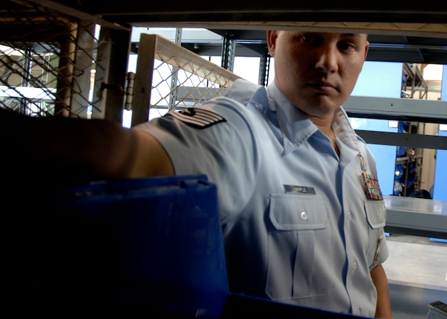 Tech. Sgt. Matthew Maple places a training aide in a locker for a military working dog to sniff out during a bomb detection exercise at the security forces warehouse Sept. 23. This type of training is conducted every month to ensure all military working dogs are able to recognize a variety of explosives, narcotics and in some cases, suspects. Sergeant Maple is with the 437th Security Forces Squadron K-9 unit. (U.S. Air Force photo/Airman 1st Class Timothy Taylor)