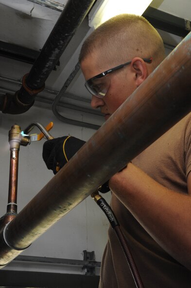 Airman Nathan Hupp, 28th Civil Engineer Squadron heating, venting and air conditioning apprentice, uses a soldering tool during renovations taking place at the Aspen Inn here, Sept. 24. The soldering tool Airman Hupp is using connects circuit settler valves to heating and cooling valves which give rooms the ability to cool down, as well as heat up. (U.S. Air Force photo/Airman First Class Adam Grant)