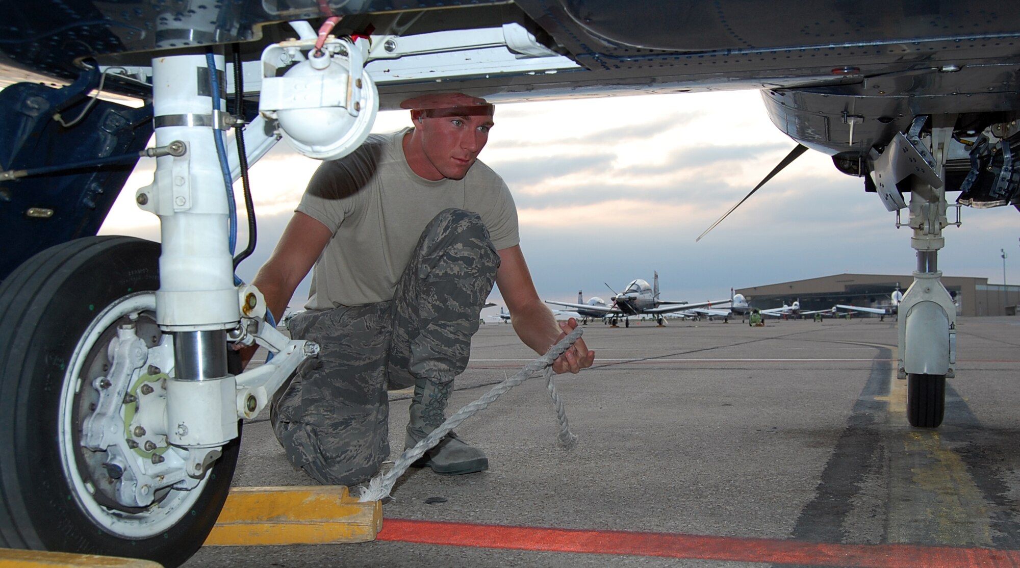 LAUGHLIN AIR FORCE BASE, Texas—2nd Lt. Kevin Hawkins, 47th Operation Support Squadron, removes the chocks from the tires of a T-6 Texan II while he performs his casual status job as a crew chief. (U.S. Air Force photo by 2nd Lt. Cody Chiles)