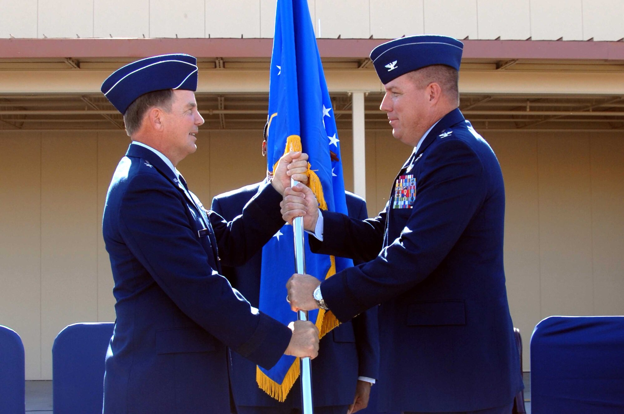 Brig. Gen. Mark Stearns, 15th Expeditionary Mobility Task Force commander, hands the 615th Contingency Response Wing guideon to the wing’s new commander Col. John Lipinski during a change-of-command ceremony Sept. 23. (U.S. Air Force photo/Nan Wylie)
