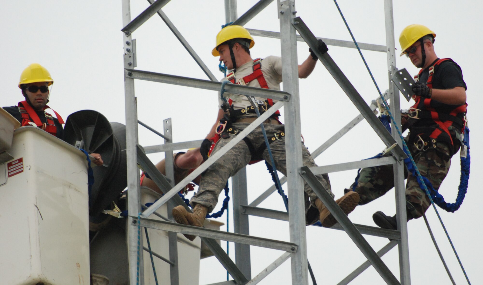 MCCONNELL AIR FORCE BASE, Kan. -- Supended at 50 feet, Airmen from the 22nd Communications Squadron and Air National Guardsmen from the 210th Engineer Installation Squadron, Minnapolis, Minn., attach brackets to adjoining pieces of air to ground transmit receiver tower, Sept 8. (photo by Airman 1st Class Jessica Lockoski)