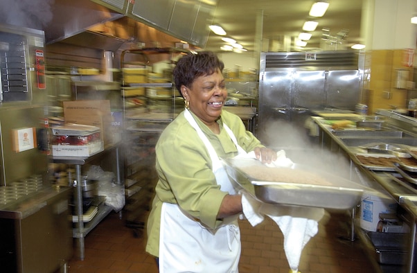 Mattie Curtis opens the kitchen in Café 3001 well before the first breakfast is served at 6 a.m. Ms. Curtis has worked here for 31 years and despite having to wake up in the middle of the night for her early morning shift, she says she’s “blessed every morning that she can get up.” Here, she’s moving a steaming pan of meat for breakfast burritos. The food from this kitchen goes out to satellite restaurants around base.(Air Force photo/Margo Wright)