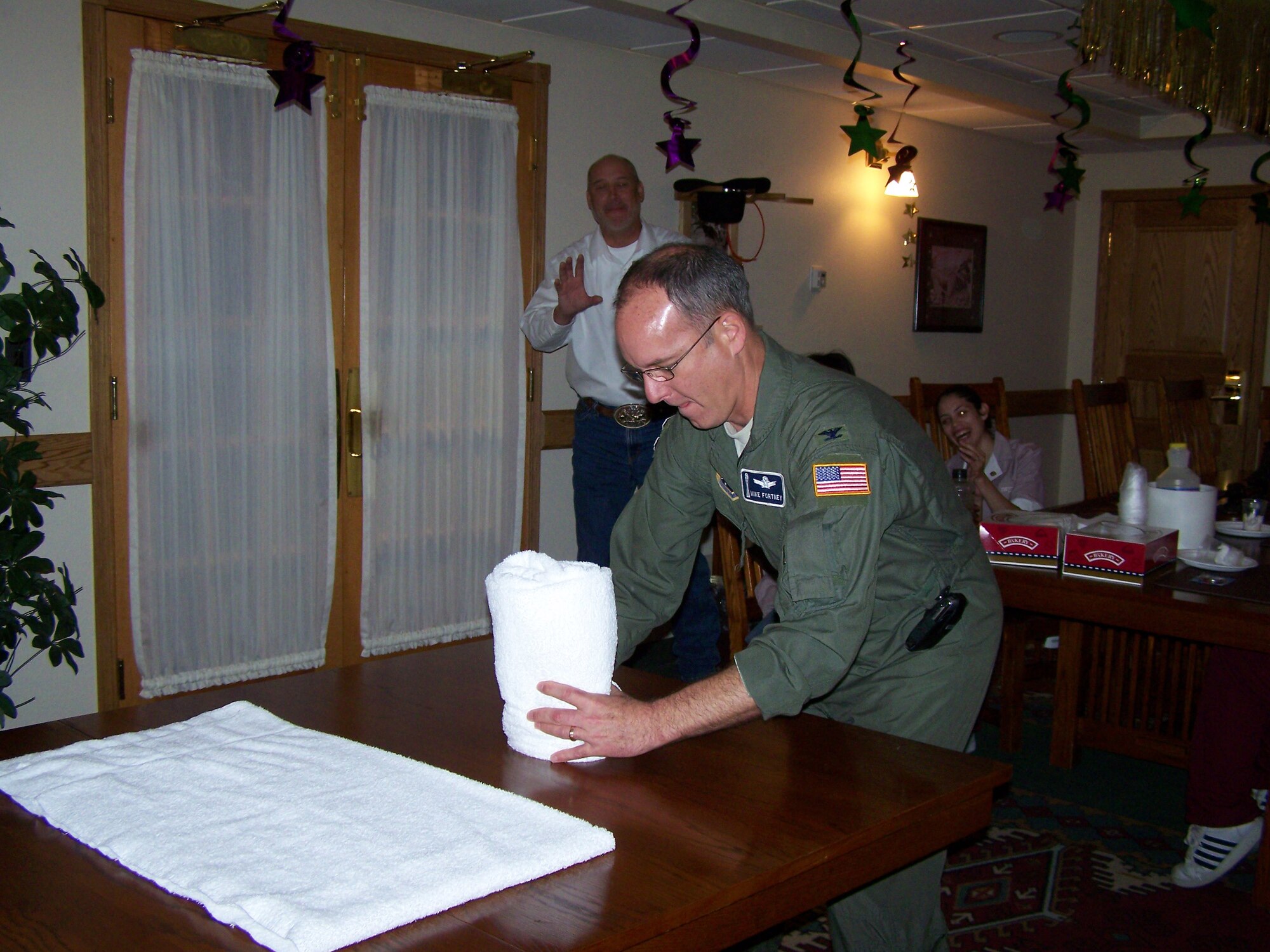 Col. Michael Fortney, 341st Missile Wing commander, attempts to fold a towel, lodging-style, during the National Housekeeping Week competition at the base hotel Sept. 20. (Courtesy photo)