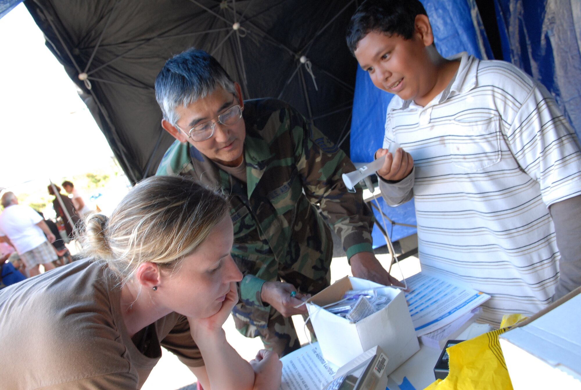 SSgt Sarah Johnson, 149th Medical Group, San Antonio, TX and MSgt Alan Yonishige, 154 Medical Group, HIANG use a spirometer to assess the lung function of Jonah Cabiles, of Kahuku.  The free asthma screening was part of the community based project E Malama Ka