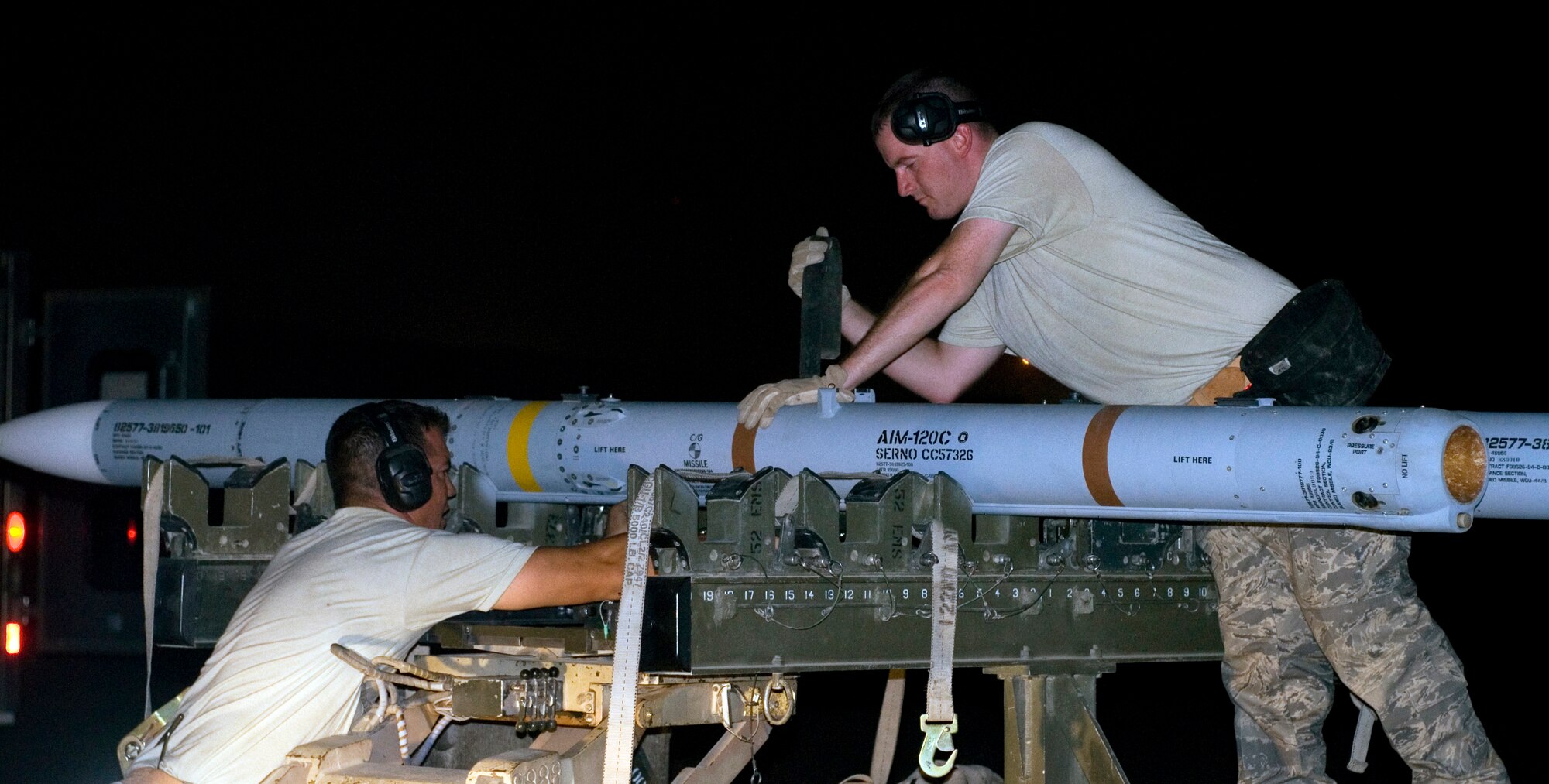 Staff Sgts. Terry Boom and Matthew Edwards secure an AIM-120C air-to-air missile onto a bomb lift truck after removing it from an F-16 Fighting Falcon at Joint Base Balad, Iraq, Sept. 22. The weapons load crewmembers are deployed to the 332nd Expeditionary Aircraft Maintenance Squadron from the Oklahoma Air National Guard's 138th Fighter Wing. Edwards' hometown is Owasso, Okla., and Boom?s hometown is Broken Arrow, Okla. (U.S. Air Force photo/Tech. Sgt. Erik Gudmundson)