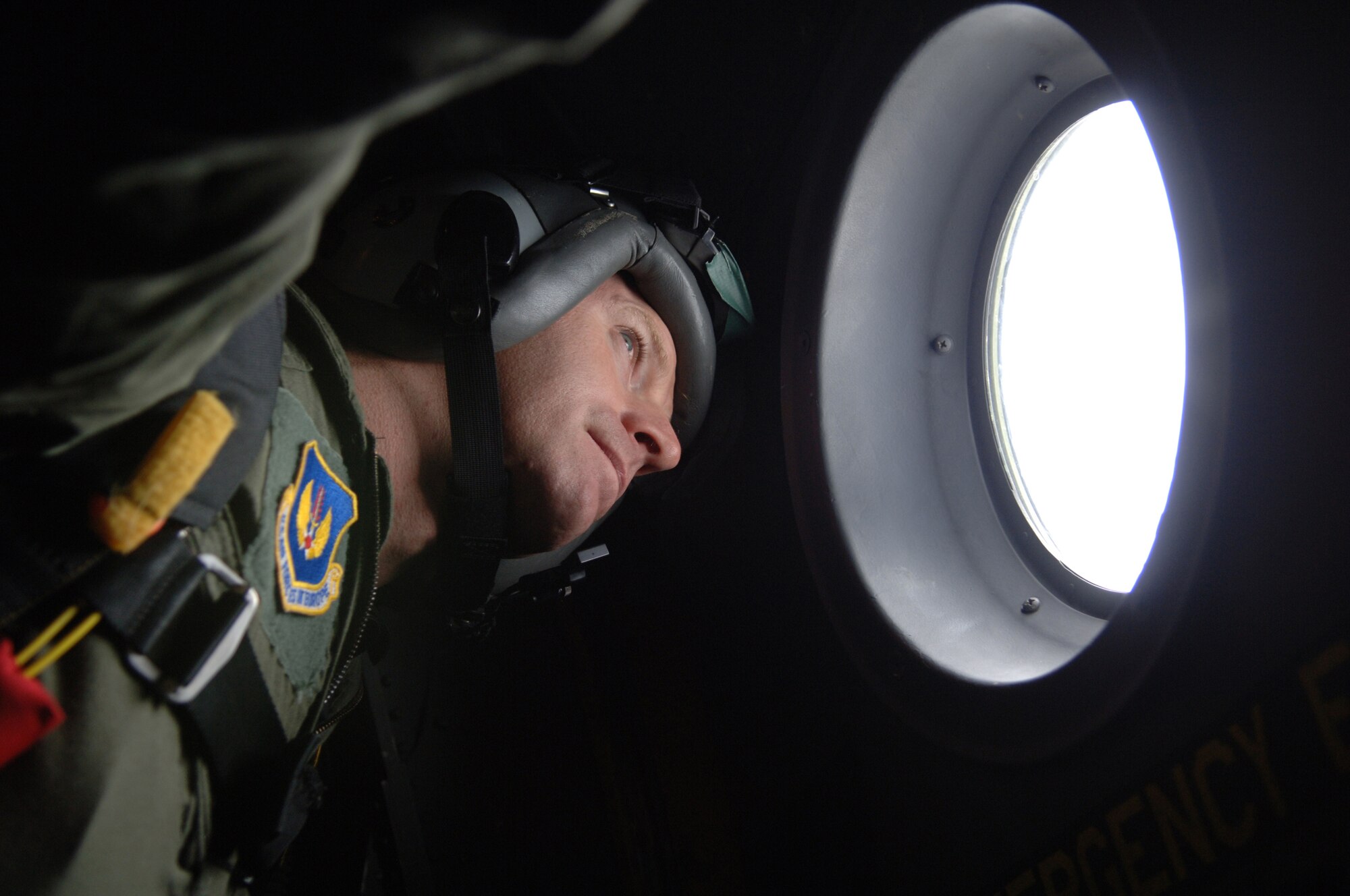 A United States Air Force pararescueman with U.S. Air Forces in Europe Headquarters, surveys the skyline out of the aircraft window before performing a HALO jump of a C-130 over Southwestern Germany, Sept. 24, 2008. (U.S. Air Force photo by Airman 1st Class Tony R. Ritter)(Released)