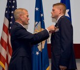 Maj. Gen. Stephen Miller, LeMay Center commander and Air University vice commander, pins the second of two medals on 2nd Lt. Anthony Florentine during a ceremony Tuesday at Officer Training School. Lieutenant Florentine was presented with a Bronze Star and a Combat Action Medal for his deployment to Baghdad as an enlisted Airman. (Air Force photo by Sarah Blake)