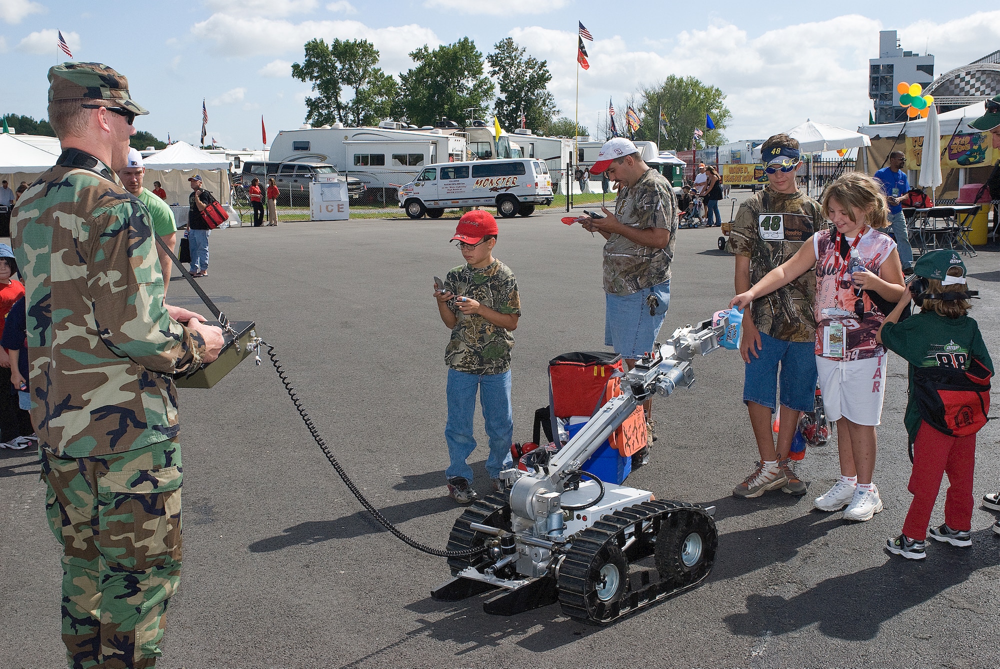 DOVER, Del. -- Capt. Patrick Wren, 436th Civil Engineer Squadron Explosive Ordnance Disposal Flight commander, manipulates a robot used to disarm bombs to grab a young girl's hat at the Kids Zone Saturday at Dover Downs. The Kids Zone is a part of the prerace festivities during NASCAR race weekend. (U.S. Air Force photo/Roland Balik) 