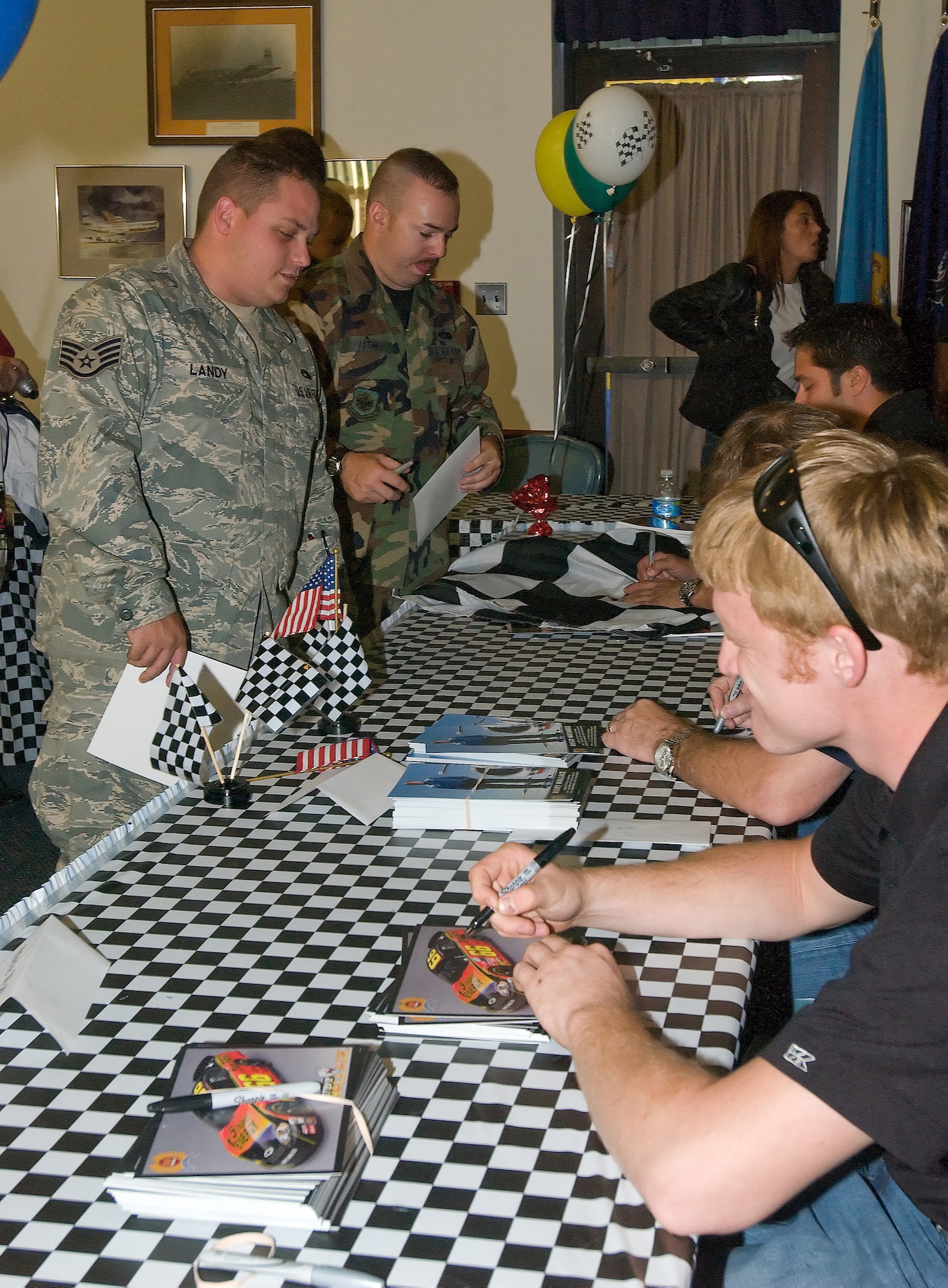 DOVER AIR FORCE BASE, Del. -- (Left) Staff Sgt. William Landy, 436th Maintenance Operations Squadron, gets autographs from more than 10 NASCAR drivers during Dover's semiannual NASCAR Social at The Landings Club Sept. 19. There was free pizza, a live band and several stock cars on display for the social. (U.S. Air Force photo/Jennie Hess) 