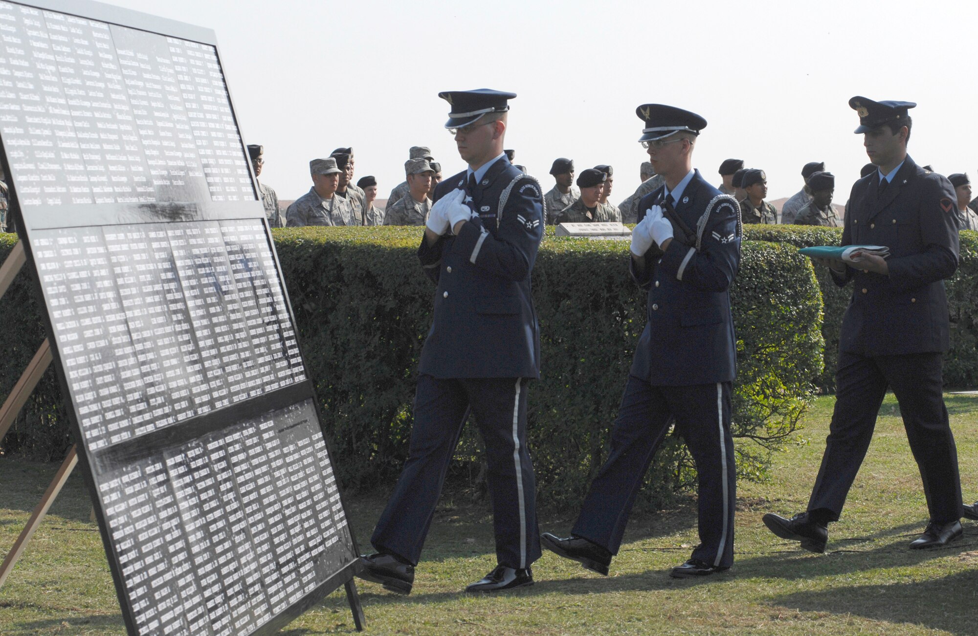 Airmen 1st Class Adam Splattstoesser and Matthew Adolph of the 31st Fighter Wing Honor Guard and Senior Airman Gianluigi Grasso, Italian Air Force Honor Guard, carry the folded U.S., POW/MIA and Italian flags past the POW/MIA wall during the base's retreat ceremony Sept. 19 in honor of National POW/MIA Recognition Day. (U.S. Air Force photo/Airman 1st Class Ashley Wood)