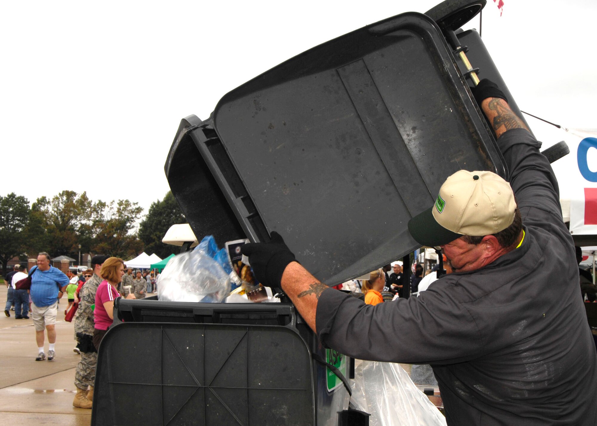 SCOTT AIR FORCE BASE, Ill. -- Aspen Waste Systems employee Richard Quirin empties out a garbage can during the Airpower Over the Midwest airshow. Timely waste disposal was a critical factor in keeping the flightline clear of debris and greatly reduced post-airshow clean-up time. 
(US Air Force photo/Senior Airman Jonathan Lovelady)
