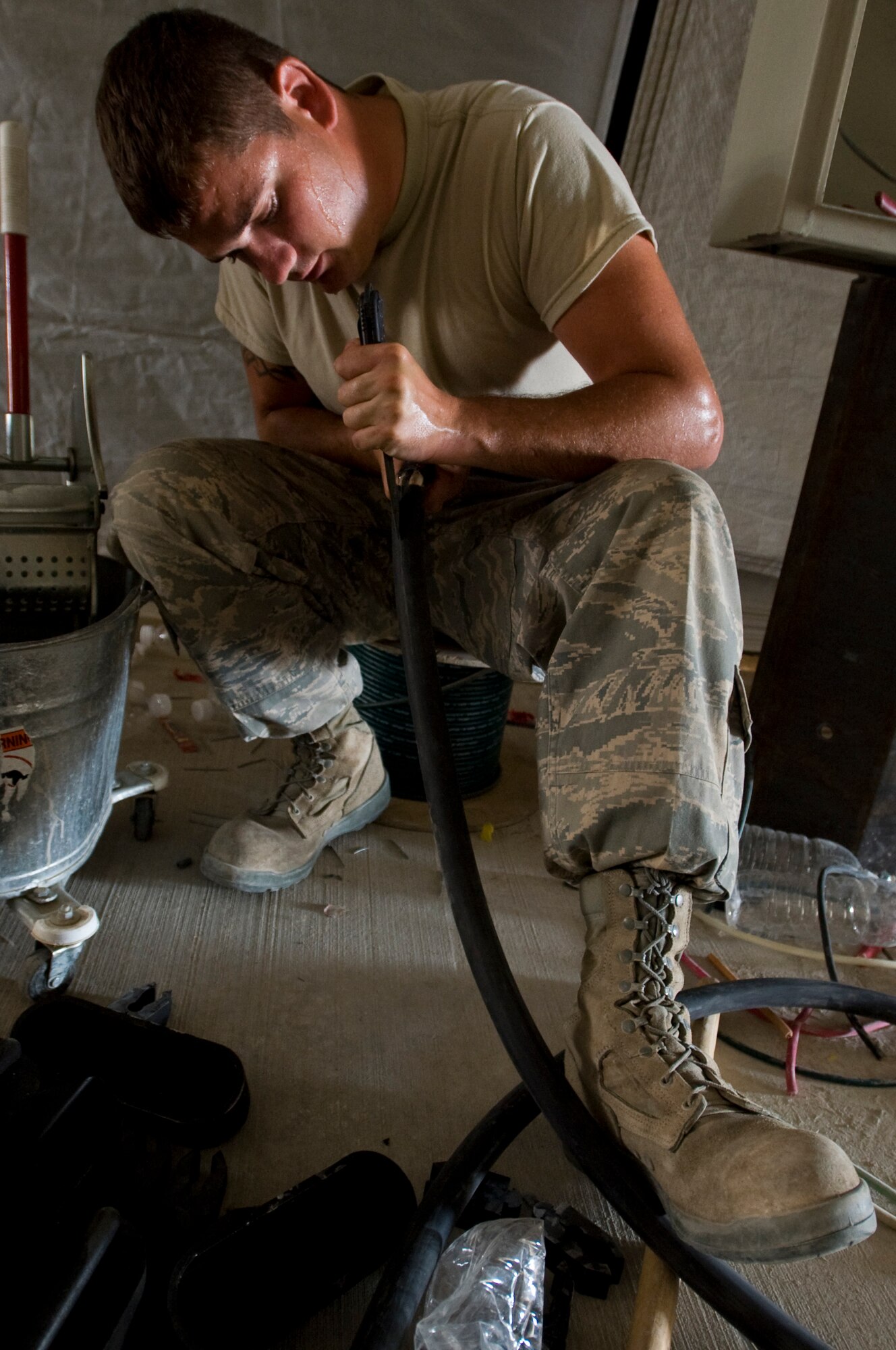 ALI BASE, Iraq -- Senior Airman Curtis Barnhill, 407th Expeditionary Civil Engineer Squadron electrician, cuts through cable insulation Sept. 24, 2008. With the relocation of the force protection facility, Airmen in the 407th ECES Power Pro shop are installing a new power supply and light fixtures. Barnhill is deployed from F.E. Warren Air Force Base, Wyo. (U.S. Air Force photo/Airman 1st Class Christopher Griffin)