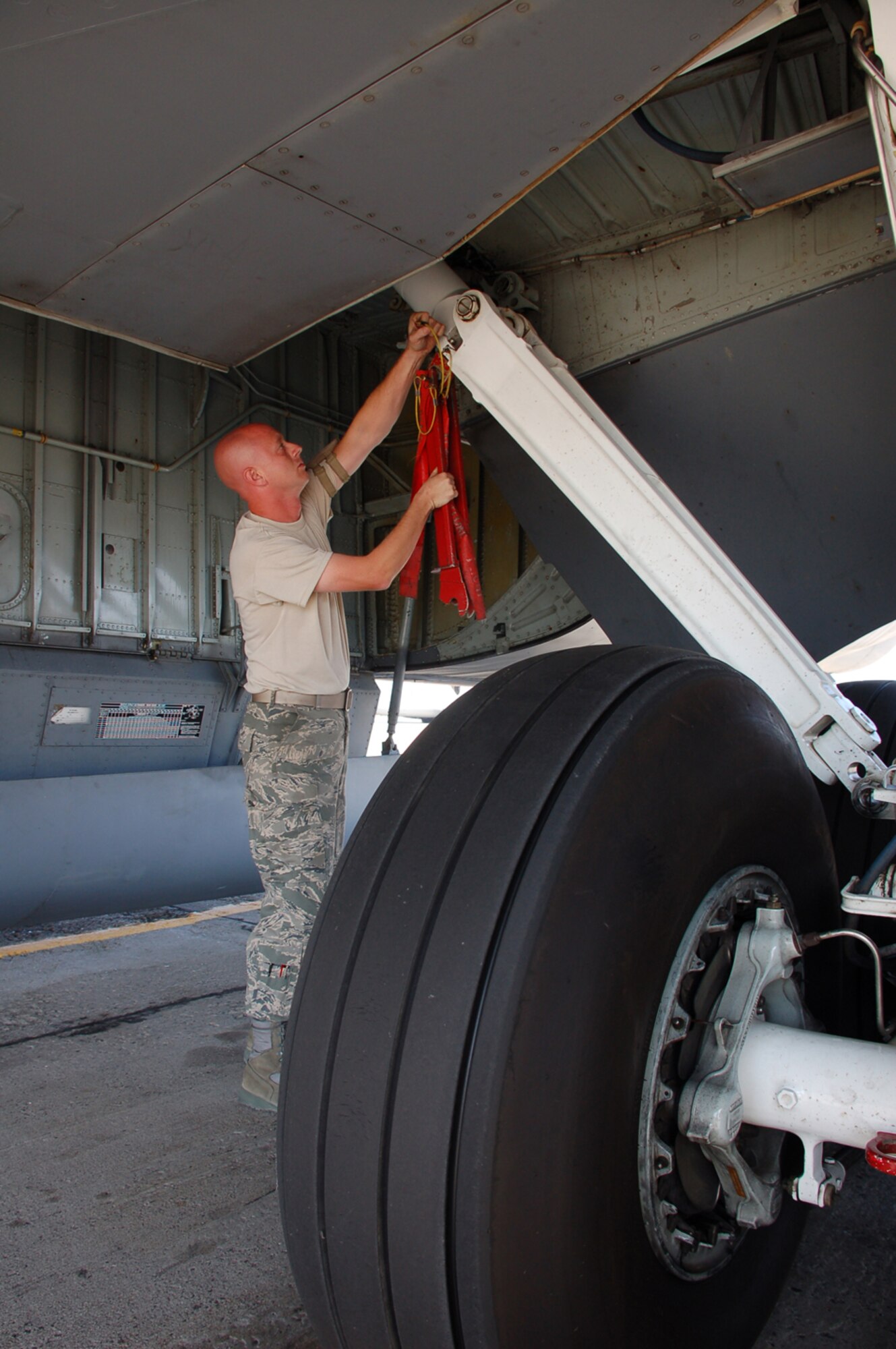 MANAS AIR BASE, KYRGYZ REPUBLIC -- Staff Sergeant Brad Michaelson, a KC-135 crew chief deployed here with Pittsburgh's 171st Air Refueling Wing, removes the main landing gear downlock pins as he prepares the aircraft for an air refueling mission over Afghanistan, Sept. 9. Sergeant Michaelson is deployed with nearly 120 other Guardsmen and four KC-135 Stratotankers from the 171st ARW. Deployed through November, the unit is assigned to the 376th Air Expeditionary Wing, which serves as the premier air mobility and refueling hub in support of military operations in Afghanistan. (Air Force photo / Maj. Damien Pickart)