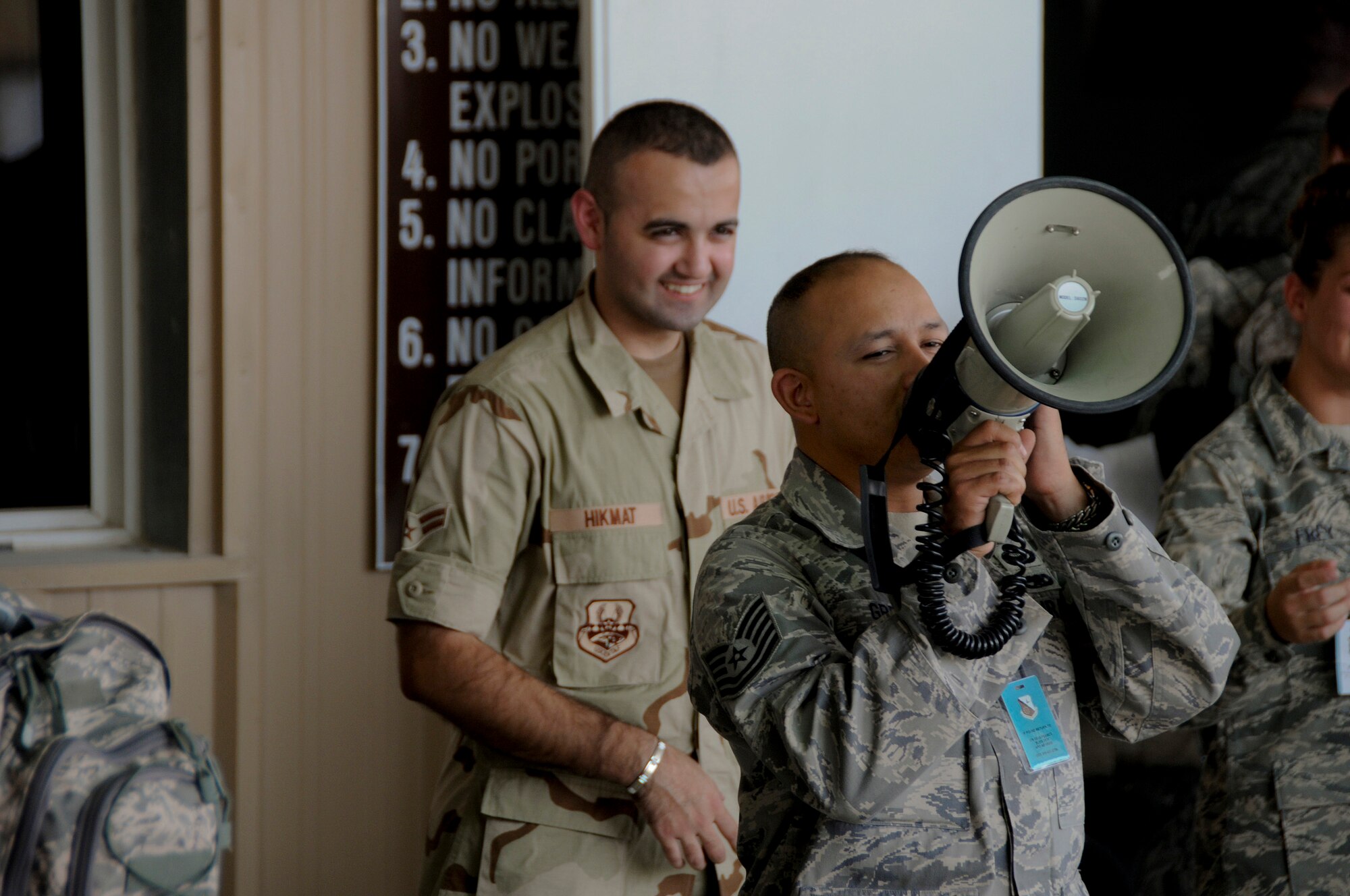Tech. Sgt. Jamil Greene, 379th Expeditionary Force Support Squadron, Personnel Support for Contingency Operations (PERSCO), announces identification cards are ready for pickup by new arrivals during in-processing Sept. 24, 2008.  Personnel who are deploying in Air Expeditionary Force 5/6 are rotating into this undisclosed air base in Southwest Asia. The PERSCO team is responsible for the in-processing and out-processing of personnel and providing 100% accountability of U.S. military, civilian & coalition forces assigned to the base in support of Operations Iraqi and Enduring Freedom and Joint Task Force-Horn of Africa.  (U.S. Air Force photo by Tech. Sgt. Michael Boquette/Released)