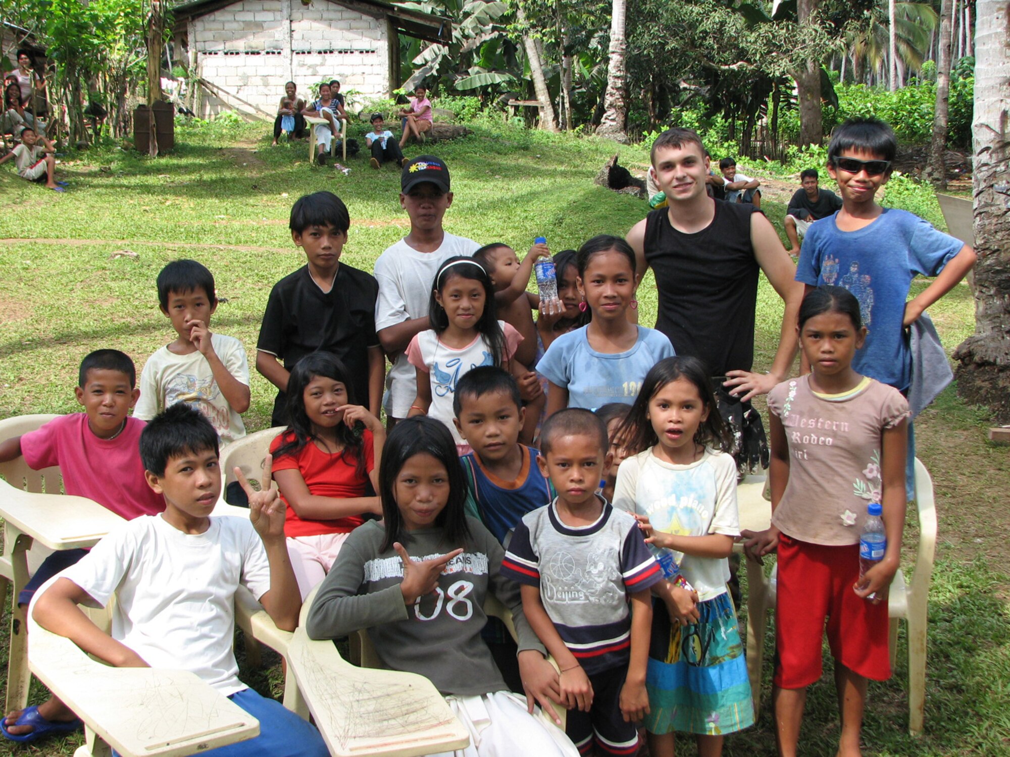 TAWI-TAWI, Philippine -- Airman 1st Class Joe Mattingly, 35th Civil Engineer Squadron engineer, poses with children in Tawi-Tawi, a Philippine province, during Balakatan '08 Feb. 29, 2008. Airman Mattingly worked with other Misawa and PI engineers to renovate an elementary school in Tawi-Tawi. This part of the exercise focuses on humanitarian and civic assistance. (U.S. Air Force courtesy photo) 

