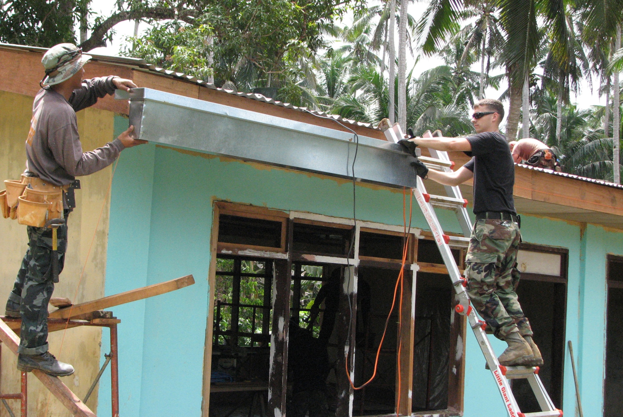 TAWI-TAWI, Philippine -- Airman 1st Class Joseph Mattingly (right), 35th Civil Engineer Squadron engineer, installs part of a rain gutter with a Philippine engineer during Balakan '08 in Tawi-Tawi, a Philippine province Feb. 25, 2008. The term Balikatan is a Tagalog word which means "shouldering the load together," which characterizes the philosophy and intent of the exercise. (U.S. Air Force courtesy photo) 
