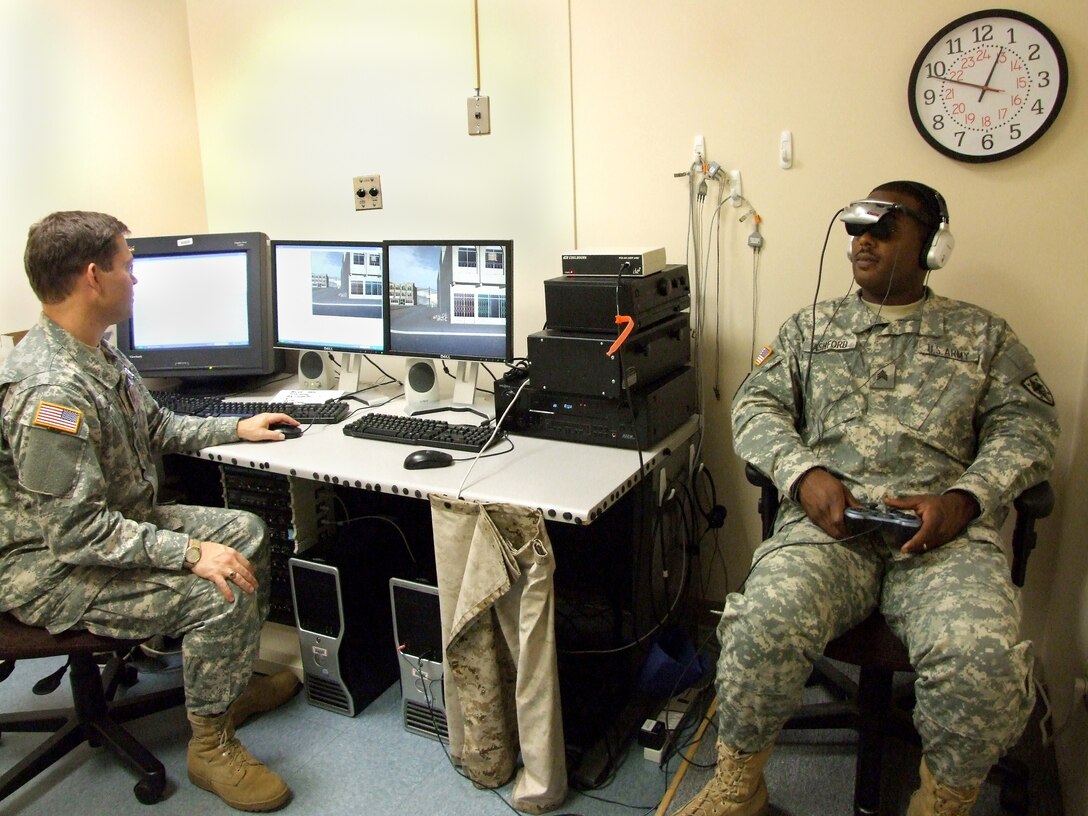Army Col. Michael J. Roy, who oversees the "Virtual Iraq" exposure therapy at Walter Reed Army Medical Center, conducts a demonstration of a life-like simulator that represents a new form of PTSD treatment with Army Sgt. Lenearo Ashford, Technical Services Branch, Uniformed Services University, on Sept. 16, 2008, in Washington, D.C. Defense Dept. photo by John J. Kruzel