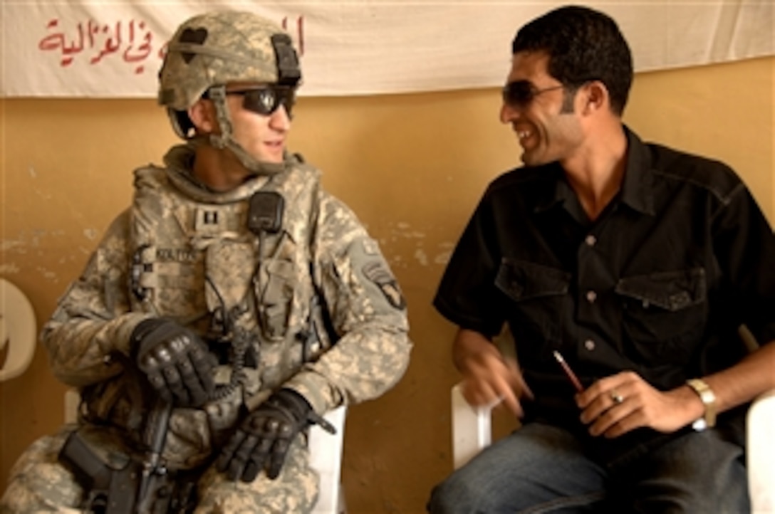 U.S. Army Cpt. Michael Kolton speaks with an employee at the neighborhood activities center prior to a business development seminar in the Gazaliyah district, Baghdad, Iraq, on Sept. 21, 2008.  Kolton is Platoon Leader, Green Platoon, Bravo Troop, 1st Squadron, 75th Cavalry Regiment, 2nd Brigade Combat Team, 101st Airborne Division.  