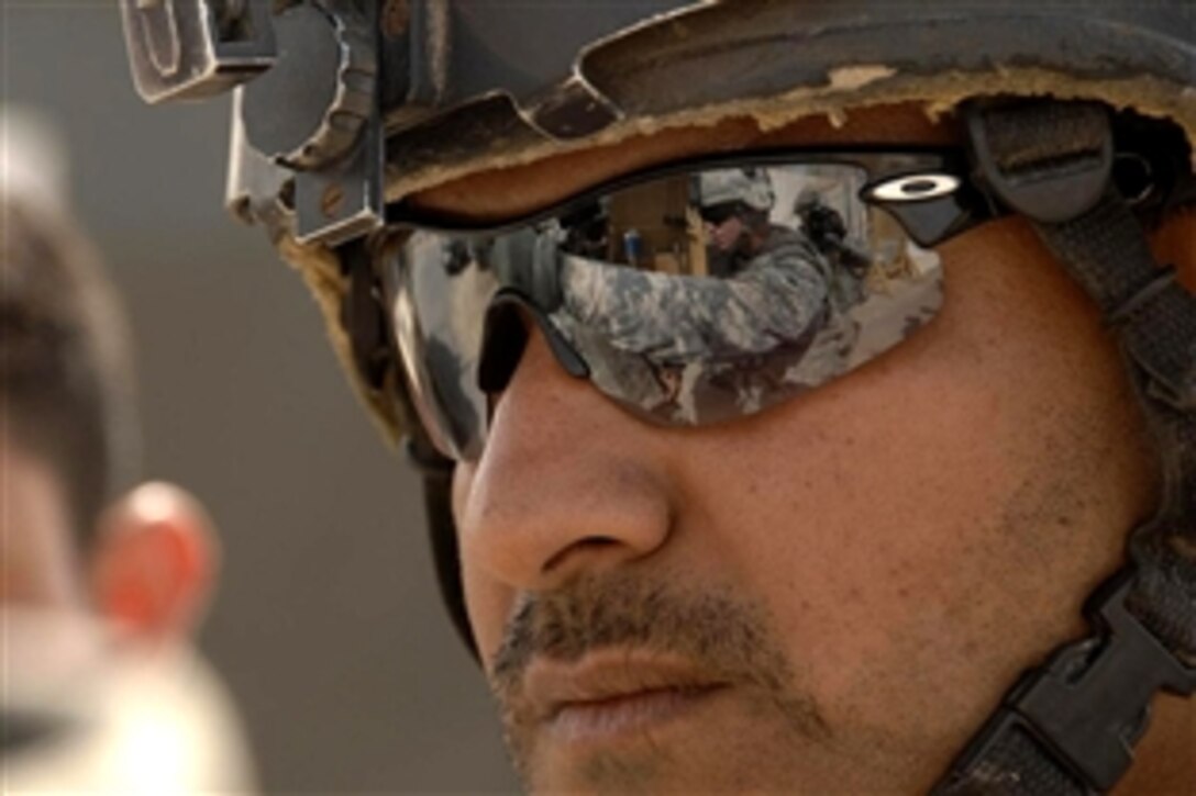 U.S. Army Staff Sgt. Jeremy Carney speaks to an Iraqi soldier at a checkpoint while on patrol in the Gazaliyah district, Baghdad, Iraq, Sept. 18, 2008. Carney is assigned to the 101st Airborne Division's 1st Squadron, 75th Cavalry Regiment, 2nd Brigade Combat Team. 
