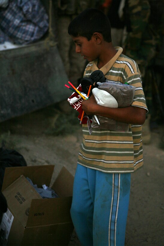 GORTAN, Iraq (September 25, 2008) – An Iraqi boy holds school supplies, which were passed out by Iraqi Police during a Combined Medical Engagement (CME) held by Company C, Task Force 1st Battalion, 2nd Marine Regiment, Regimental Combat Team 1, Sept. 25. The CME was held after sunset out of respect for the Muslim holiday of Ramadan and allowed Iraqis to obtain medical care if needed. (Official U.S. Marine Corps photo by Lance Cpl. Scott Schmidt)