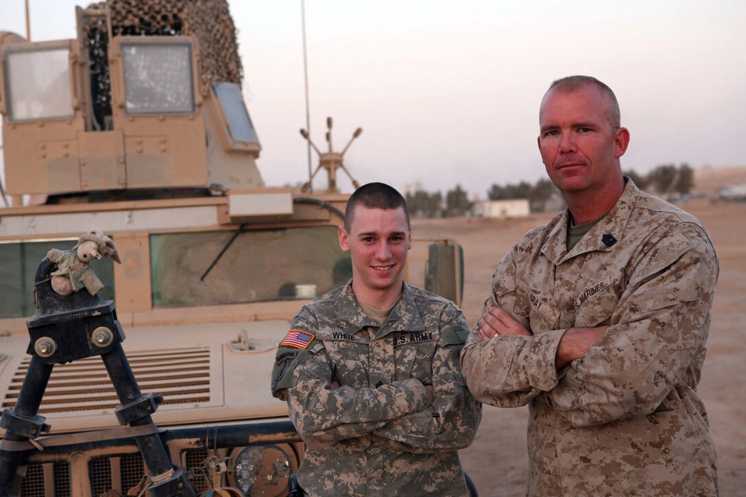 Army Sgt. Shane M. White, an information systems specialist with 4th Psychological Operations Group, and 1stSgt. Joseph C. Gray, company first sergeant, Team Tank, Regimental Combat Team 1, visit at Al Asad Air Base, Iraq, Sept. 25. Gray is White's father, and the men were seeing each other for the first time in more than a year.