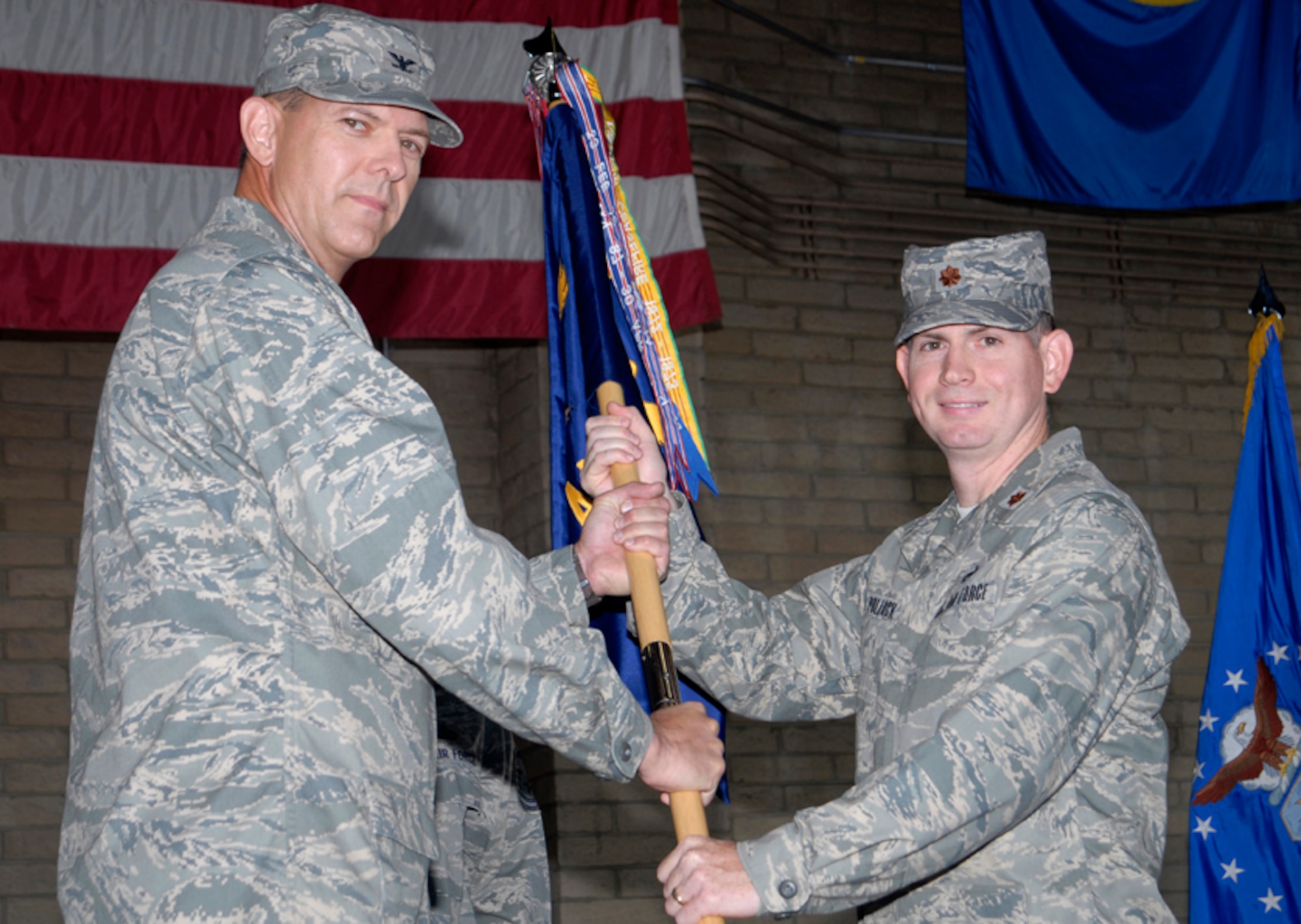 Col. Geoffrey Parkhurst, 56th Maintenance Group Commander, passes the guidon to Maj. Matthew Pollack as he assumes command of the 56th Aircraft Maintenance Squadron Monday.