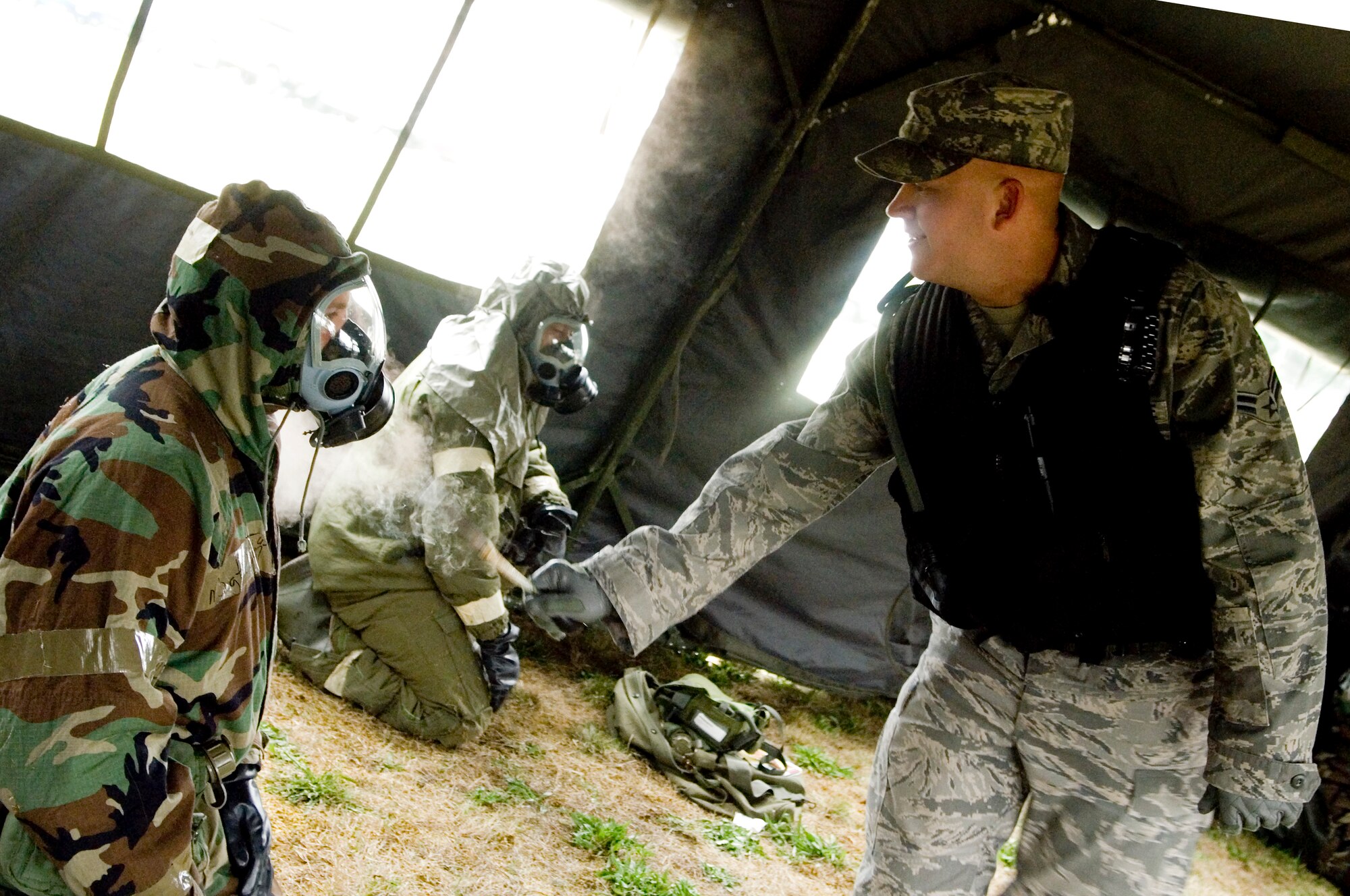 Airman 1st Class Joseph Pirtle, 62nd Civil Engineer Squadron, tests the seal
on Master Sgt. Chris Dahm’s, 62nd CES, protective mask during an exercise to
train and prepare Exercise Evaluation Team members for the upcoming wingwide
ability to survive and operate training and mobility exercise.
