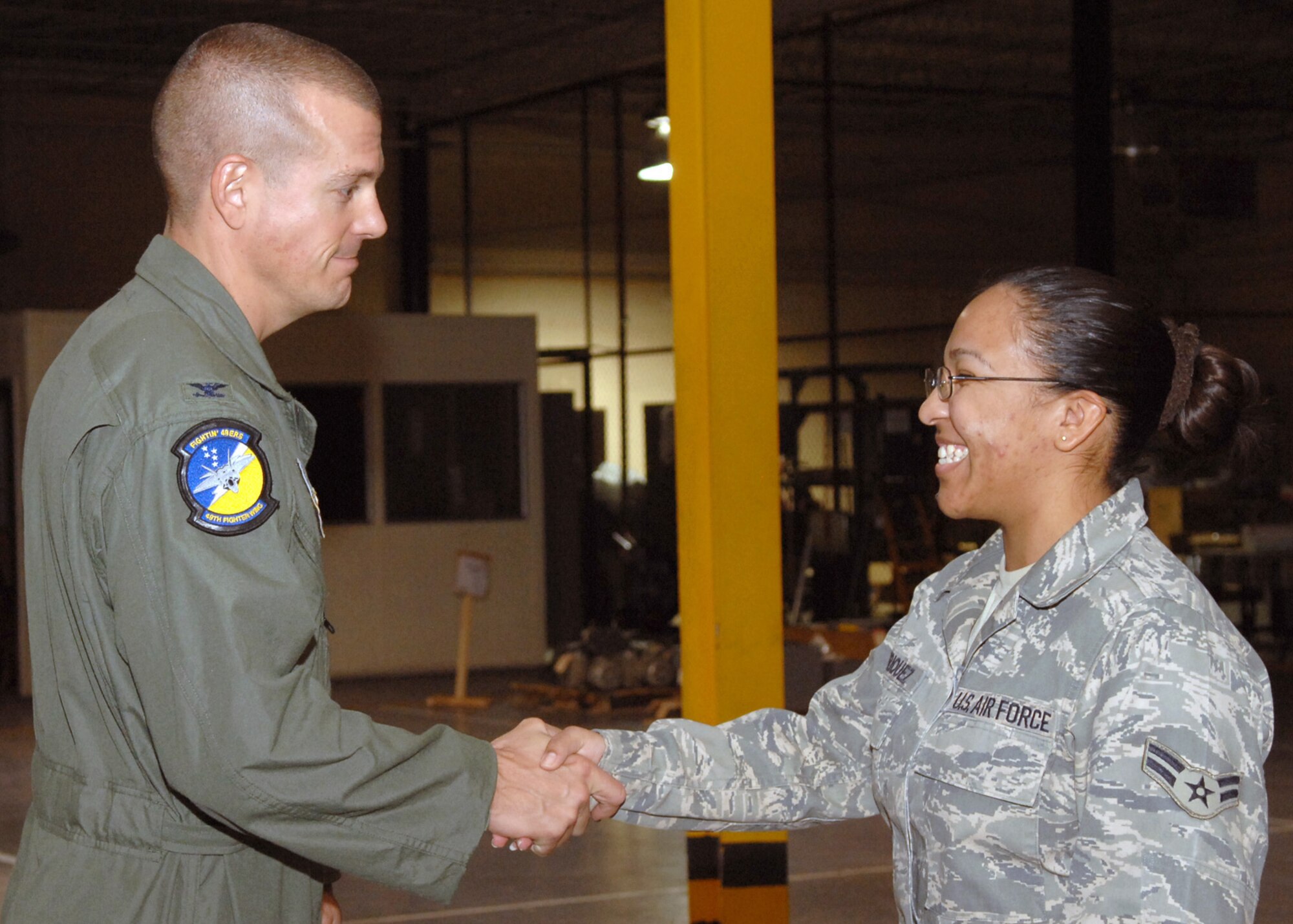 Col. Michael McGee, 49th Fighter Wing vice commander, shakes hands with Airman 1st Class Connie Enriquez, 49th Logistics Readiness Squadron, at the weapons vault at Holloman Air Force Base, N.M., September 15. Airman Enriquez just returned home fom a six month deployment to Kirkuk Air Force Base, Iraq. While deployed, she worked as a traffic management specialist. (U.S. Air Force photo/Airman 1st Class Veronica Salgado)
